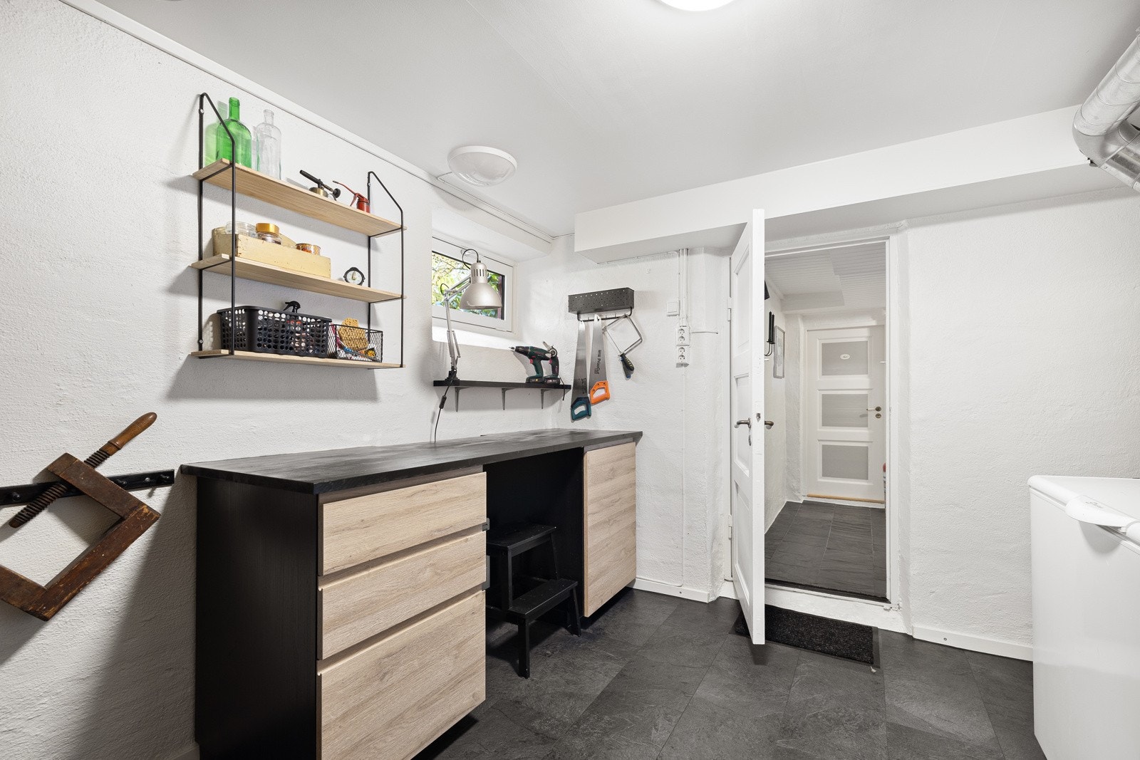 Det er god hylleplass i arbeidsboden med uttak for strøm, masse stikkontakter ved arbeidsbenken og plass til fryser. Galleribilde