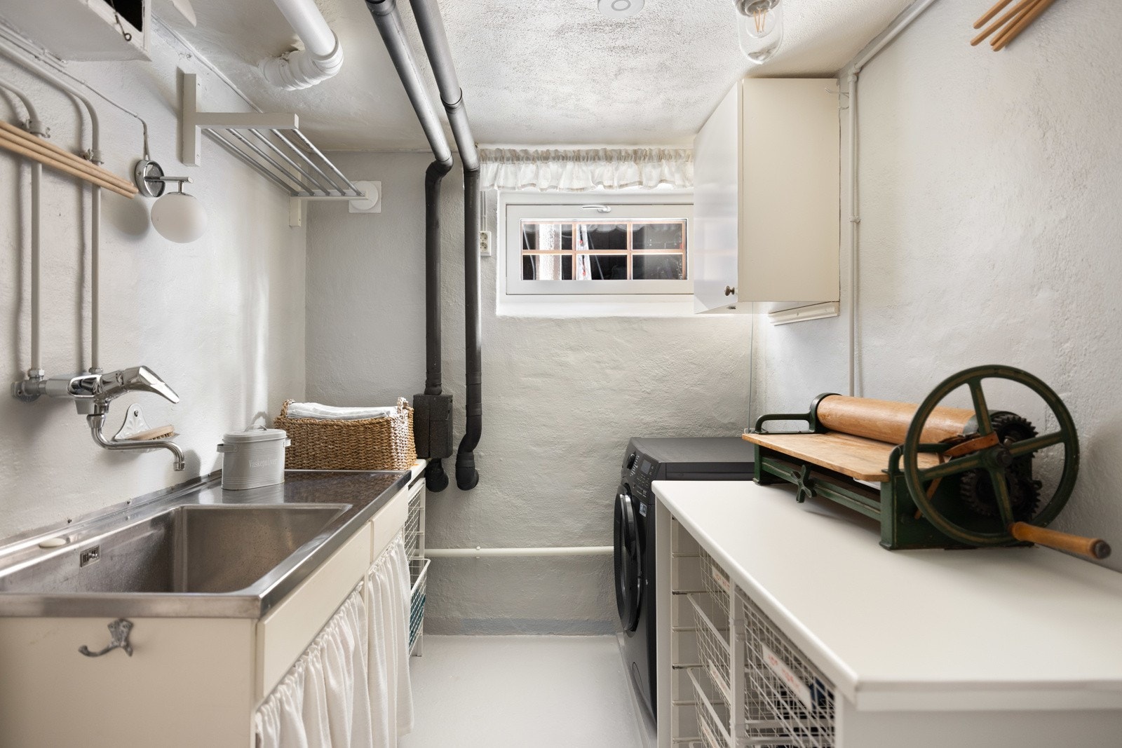 Stort praktisk vaskerom. Innredning med heldekkende utslagsvask i stål og benkeplate i laminat. Det er opplegg for vaskemaskin og god skapplass. Galleribilde