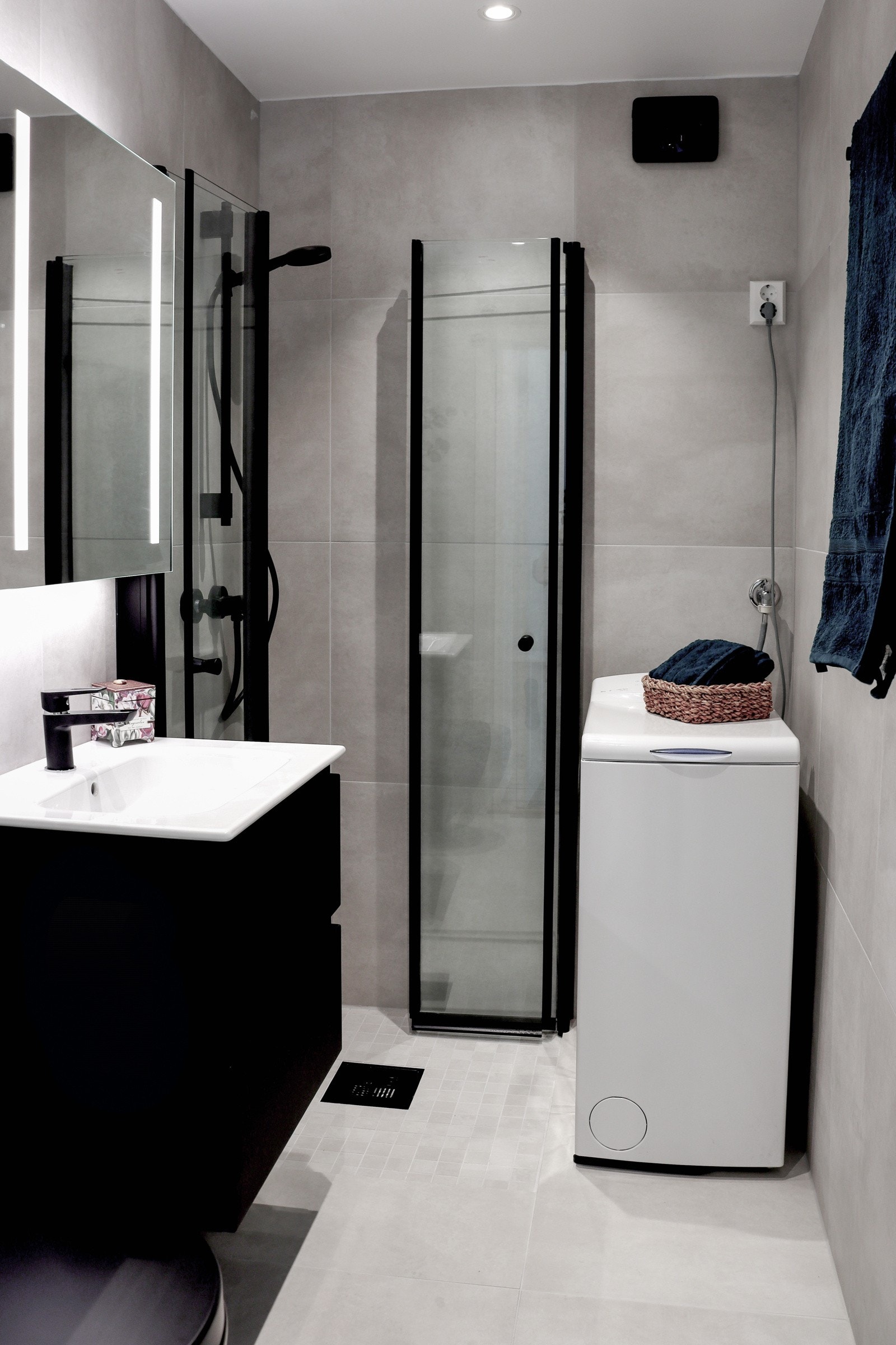 Stilig flislagt bad med elektrisk gulvvarme. Malt himling med downlights. Innredningen har slette fronter og heldekkende servant. Speil på vegg over servant. Galleribilde