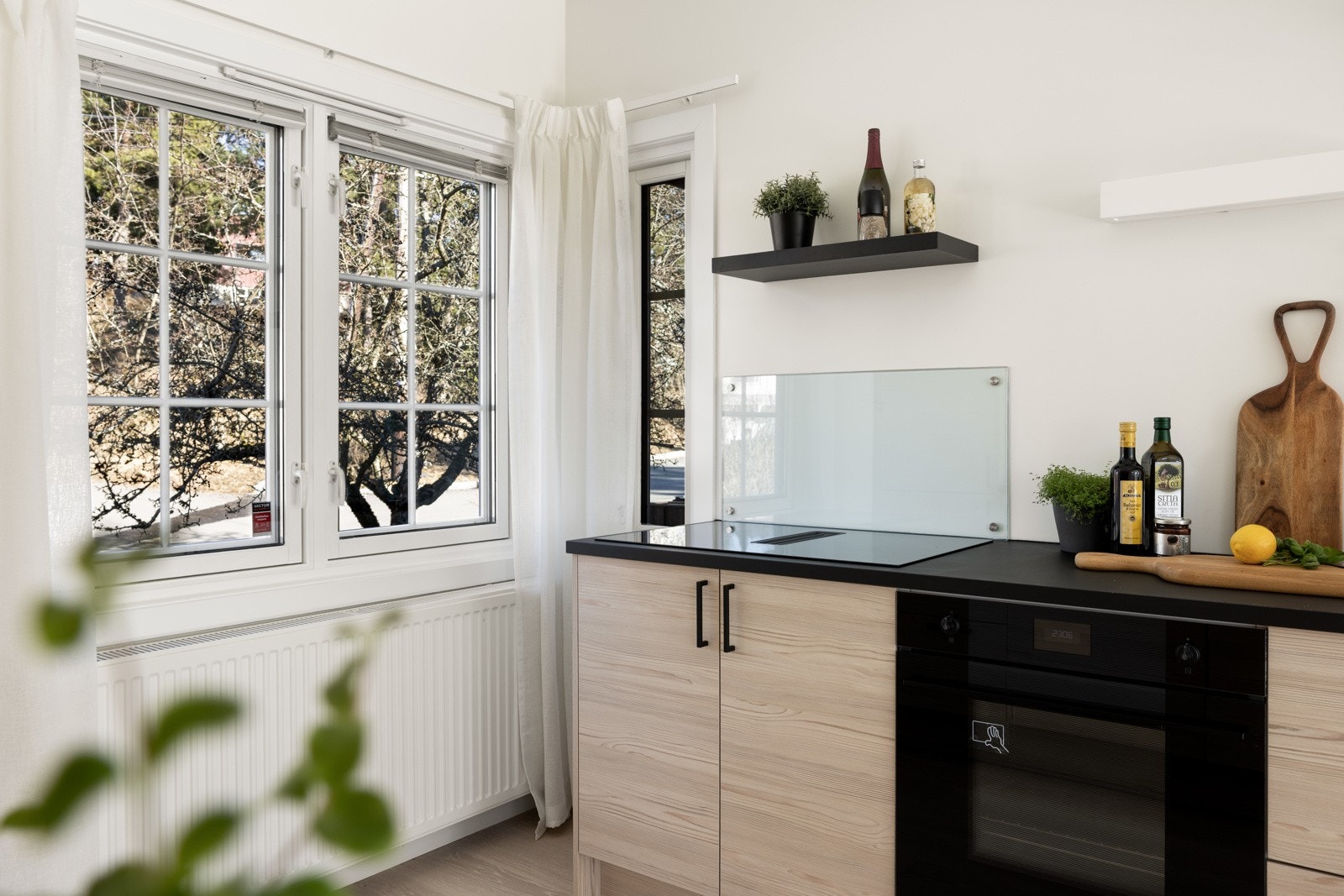 Kjøkken med hyggelig utsyn mot egen forhage med plen og frukttrær. Galleribilde
