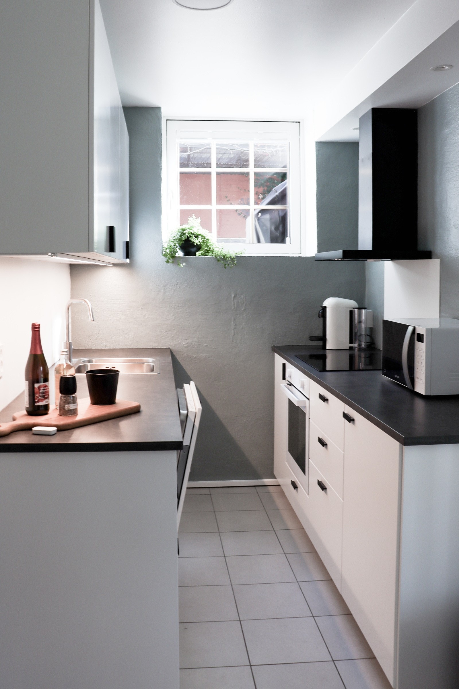 Et romslig kjøkken med ny innredning fra Ikea (2024). Innredningen har slette fronter og benkeplate av laminat. Oppvaskkum av stål. Integrert platetopp, ovn, oppvaskmaskin og kjøleskap. Avtrekk fra kullfilter. Galleribilde