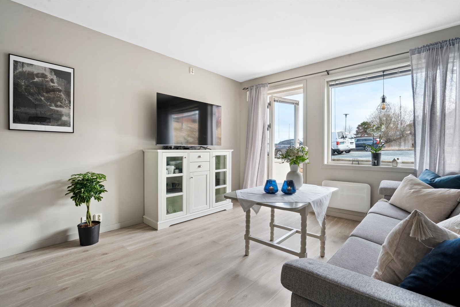 Stuen er malt i duse farger og har utgang til terrasse. Galleribilde