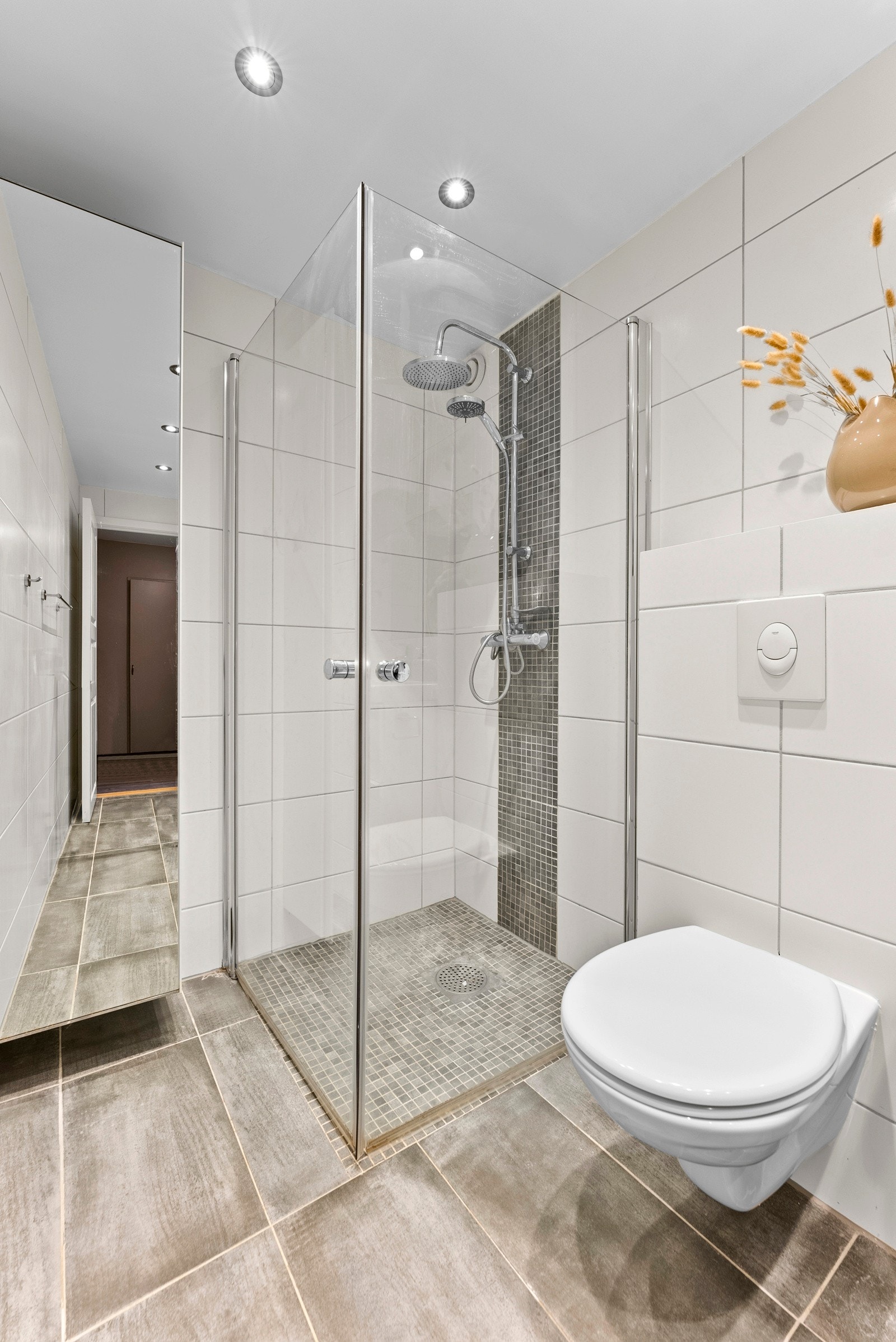 Arealet er godt utnyttet med regnfallsdusj, vegghengt toalett og høyskap i tillegg til innredningen. Galleribilde