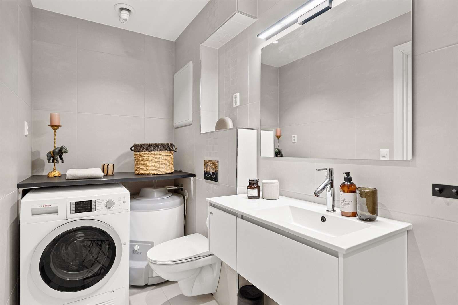 Badet inneholder: Servant med møblement/speil,
belysning, vegghengt toalett, dusjgarnityr,
innfellbart dusjhjørne
og opplegg for vaskemaskin. Galleribilde