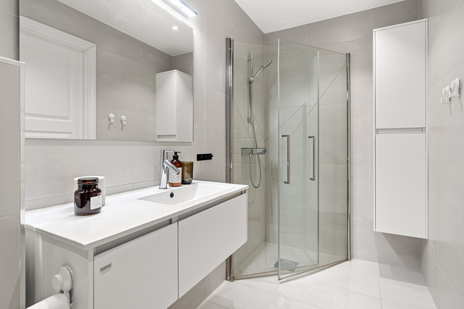 Lyst og moderne bad med stilren dusjløsning og praktisk oppbevaring. Perfekt for en funksjonell hverdag. Galleribilde