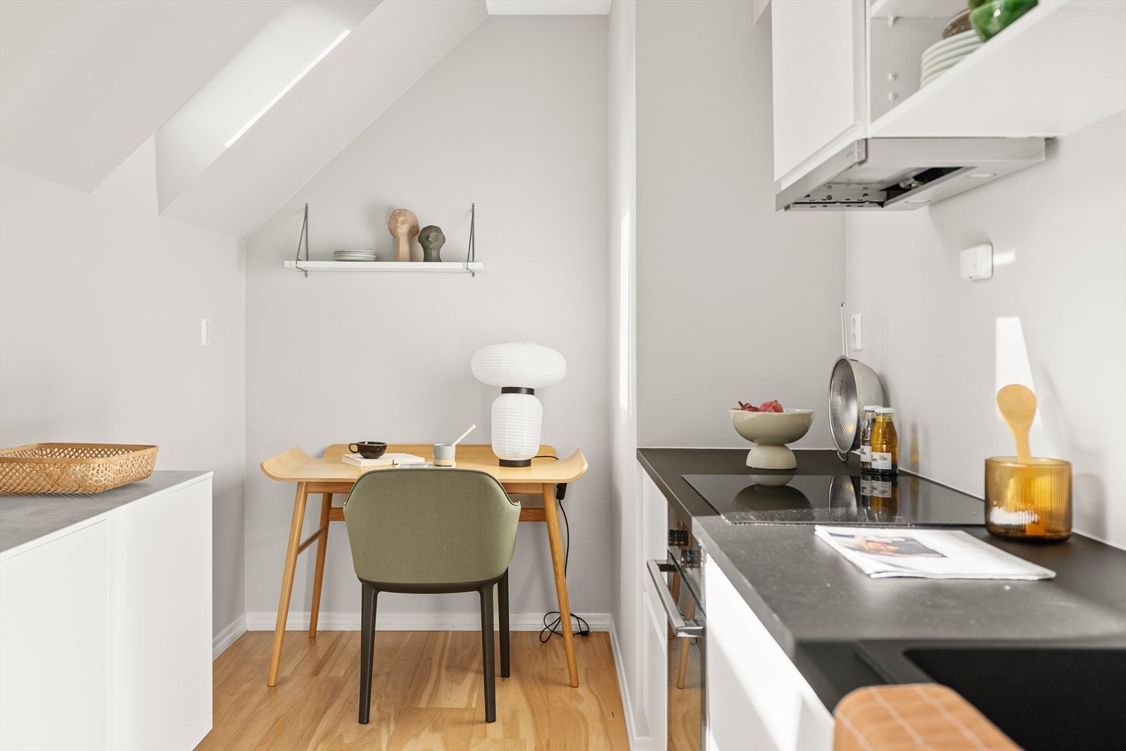 Lyst og moderne rom med skråtak, egen spiseplass eller kontorplass i enden av rommet Galleribilde