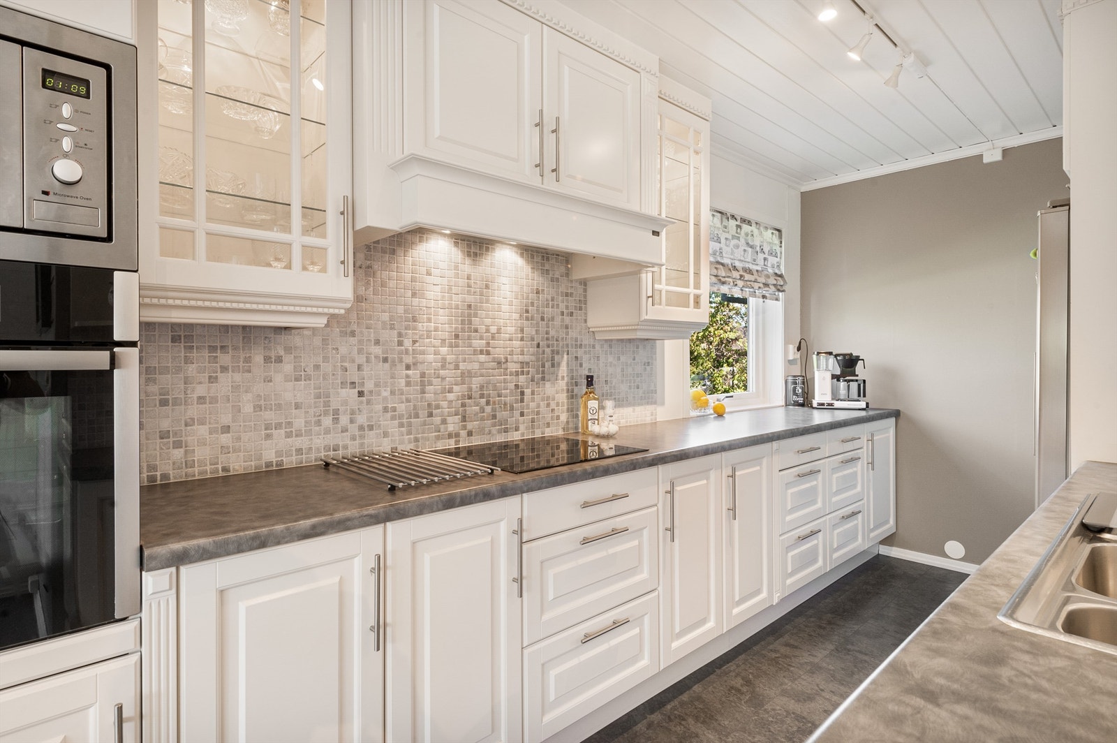 Innholdsrikt kjøkken i lys utførelse med integrerte hvitevarer Galleribilde