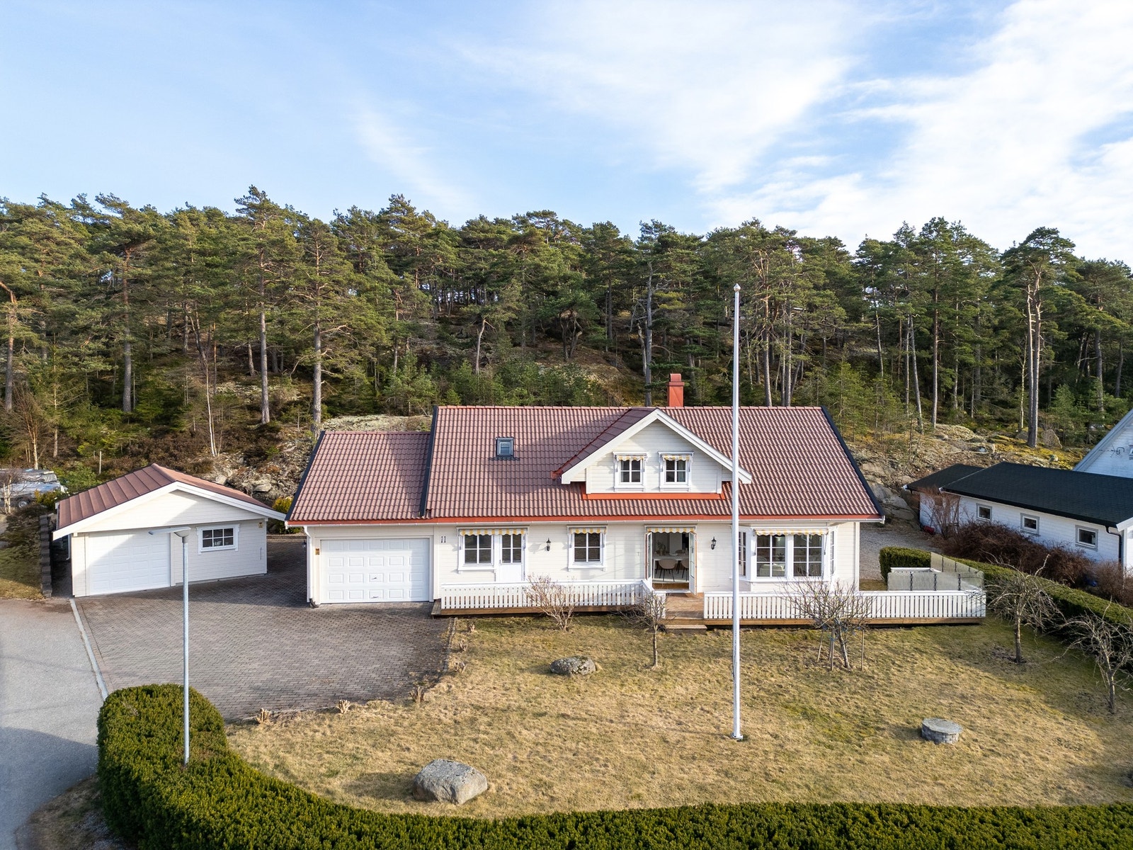 Eiendommens hage er flat med stor gressplen. Eiendommen er skjermet med hekk mot gaten i vest. Galleribilde