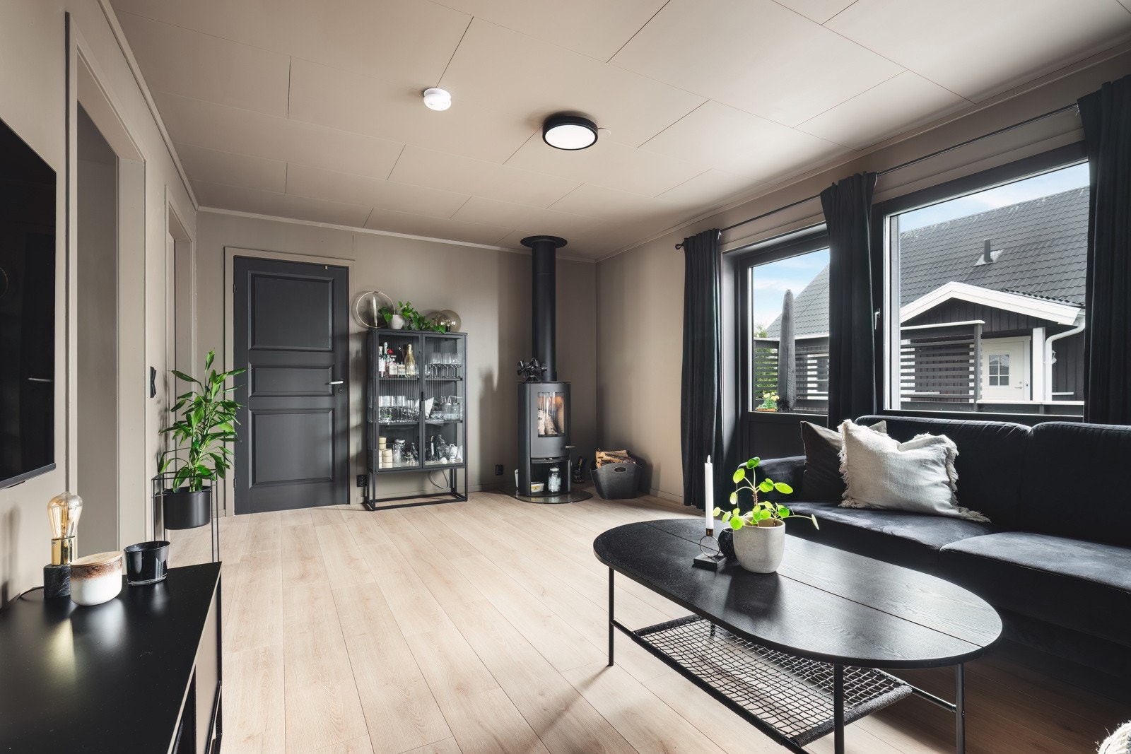 Attraktiv og moderne enebolig. Stue med koselig peis og tidsriktige overflater Galleribilde