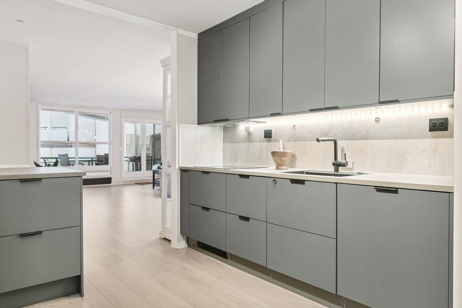 Kjøkkeninnredningen er fra 2020 med slette grå fronter m/sorte håndtak og laminert benkeplate m/nedfelt komposittvask Galleribilde