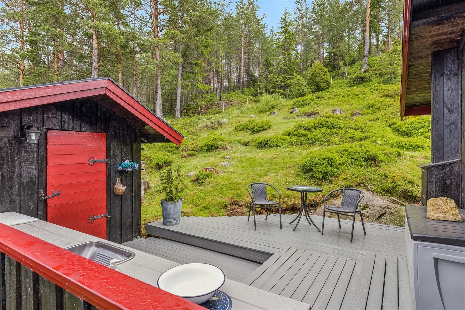 Hyggelig uteområde med stor hage og skjerming fra all den solen på fremsiden av hytten Galleribilde