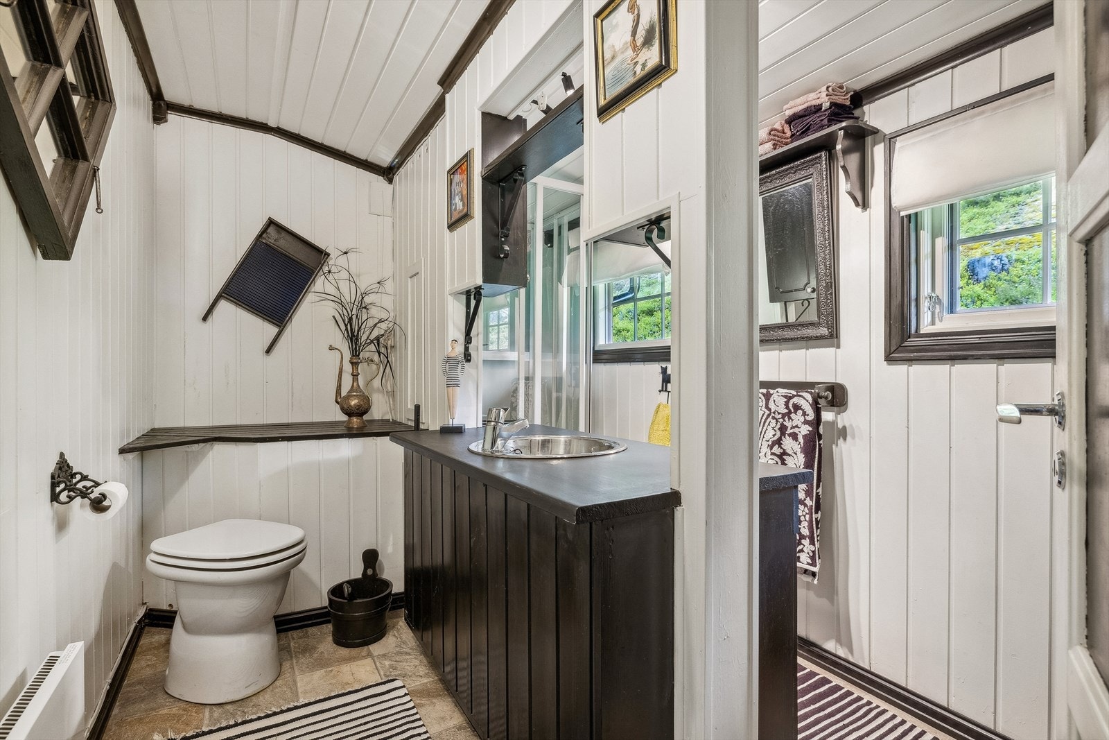 Toalettrom med snurredass, belegg på gulv og trepanel på vegger og tak. Galleribilde