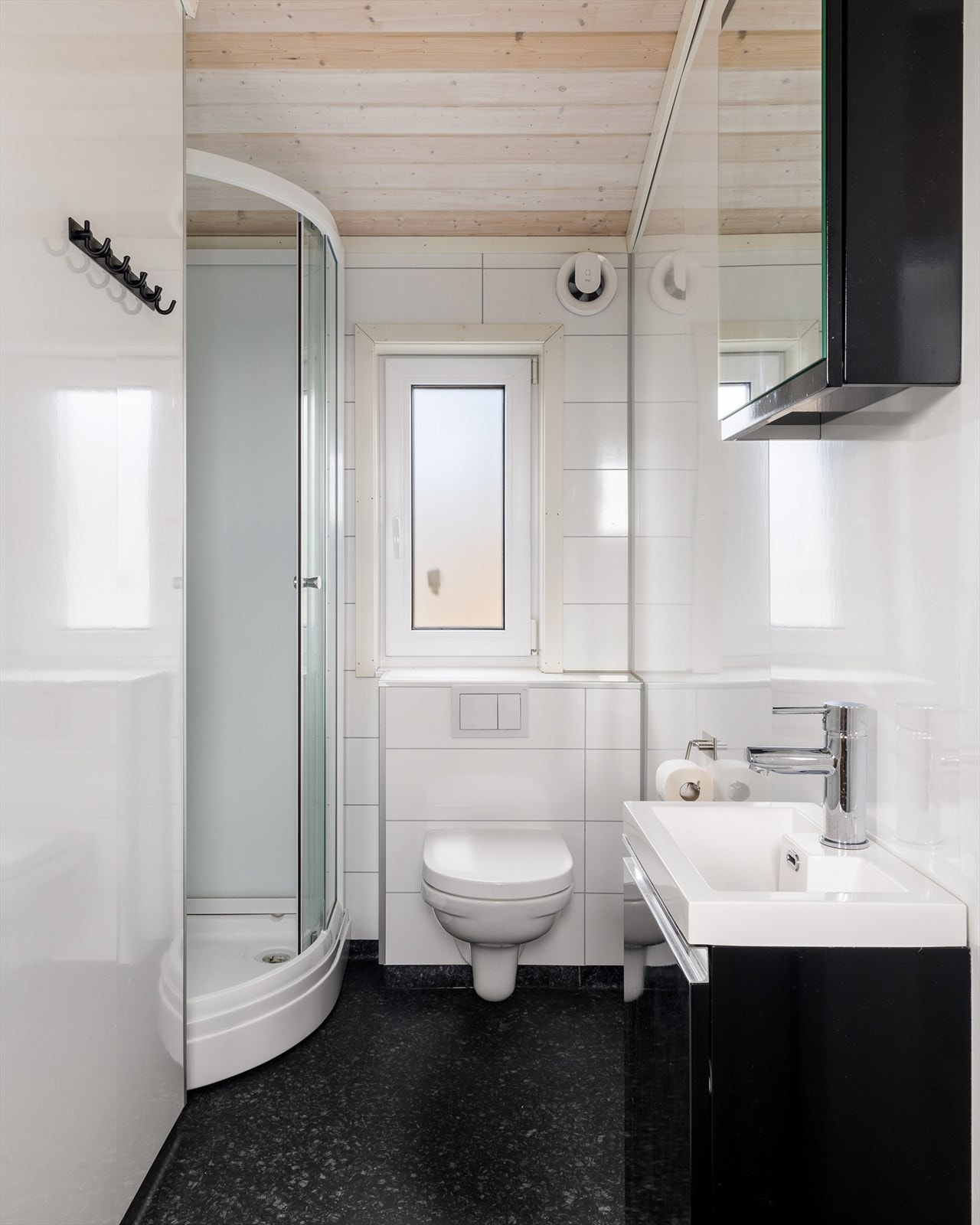 MINIMALISTISK: På badet i 2. etasje er det sort belegg på gulvet og hvite våtromsplater på veggene. Galleribilde