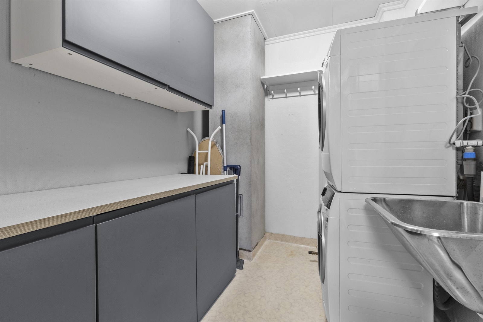 Bod/vaskerom med innredning for lagringsplass, opplegg for vaskemaskin og utslagsvask (opprinnelig godkjent som bod). Galleribilde