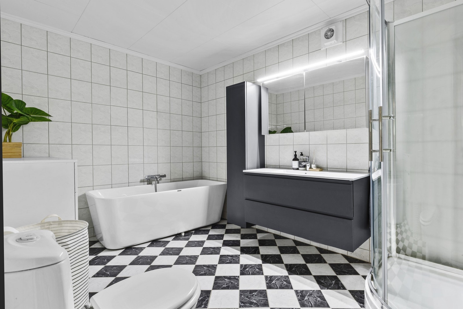 Baderom av veldig god størrelse, med toalett, badekar, servant med innredning og dusjkabinett. Galleribilde