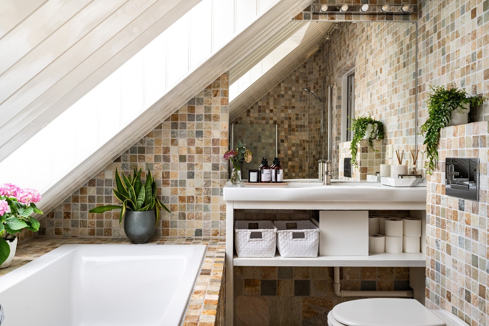 Bad nummer to har badekar, dusj og toalett, og elegante steinfliser av travertin-marmor. Galleribilde