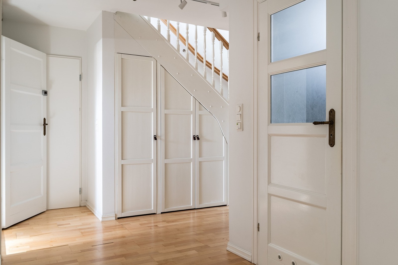 Den romslige gangen i underetasjen, med praktiske skap under trappen. Galleribilde