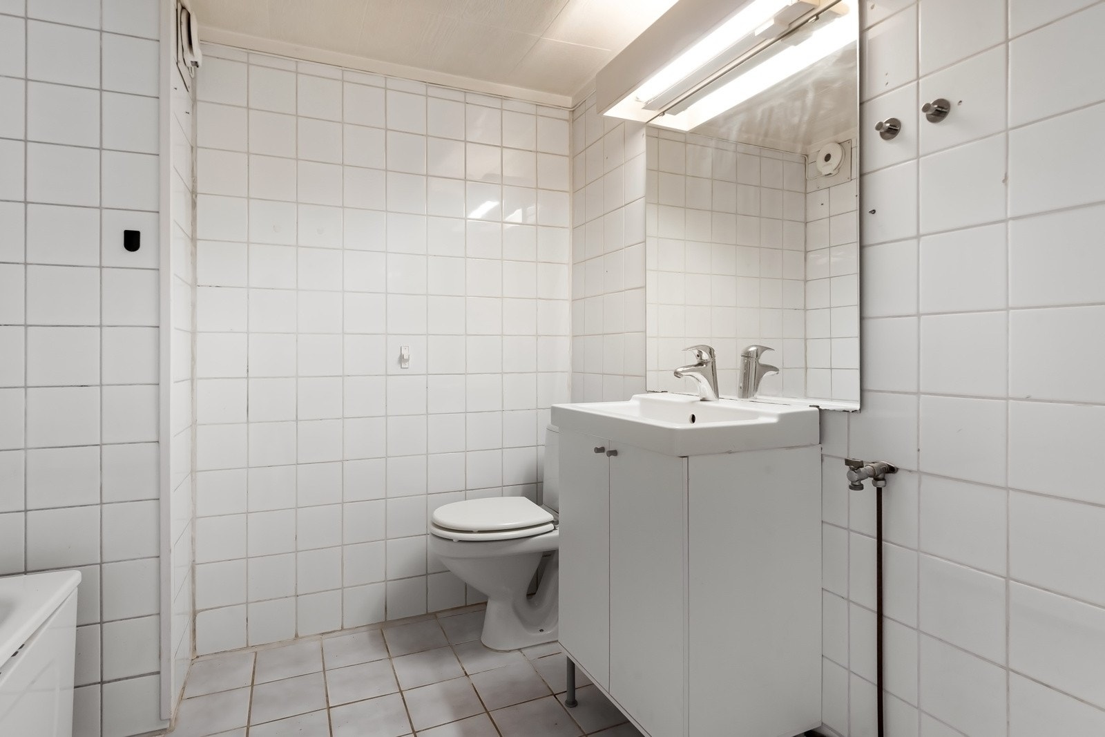 Badet er av eldre dato og fremstår med behov for renovering, men gir et godt utgangspunkt for å skape et funksjonelt og tidsriktig baderom. Galleribilde