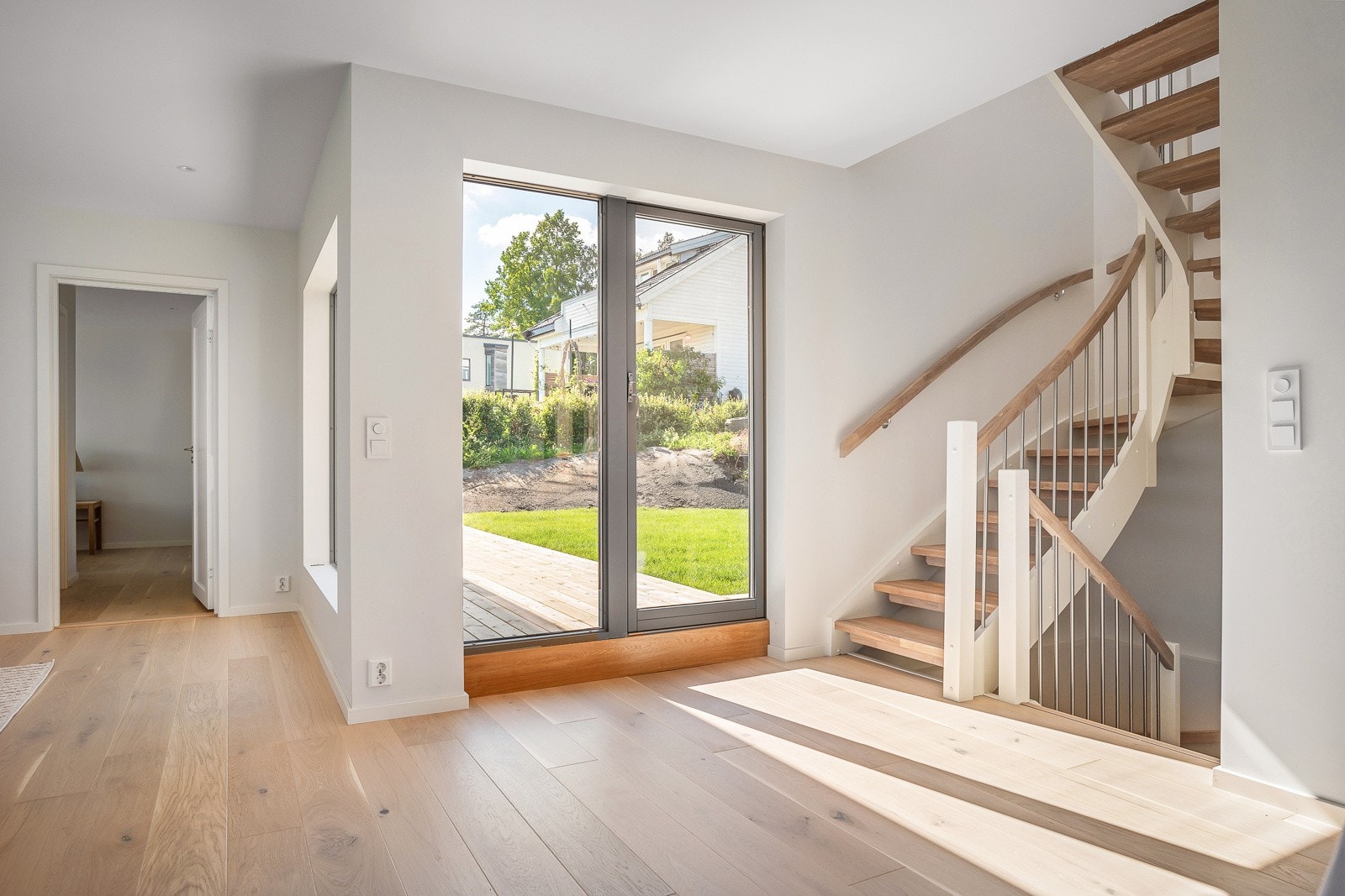 Pen svingtrappen med hvitgrunnede vanger og håndløper, og åpne kortstav eiketrinn. Galleribilde