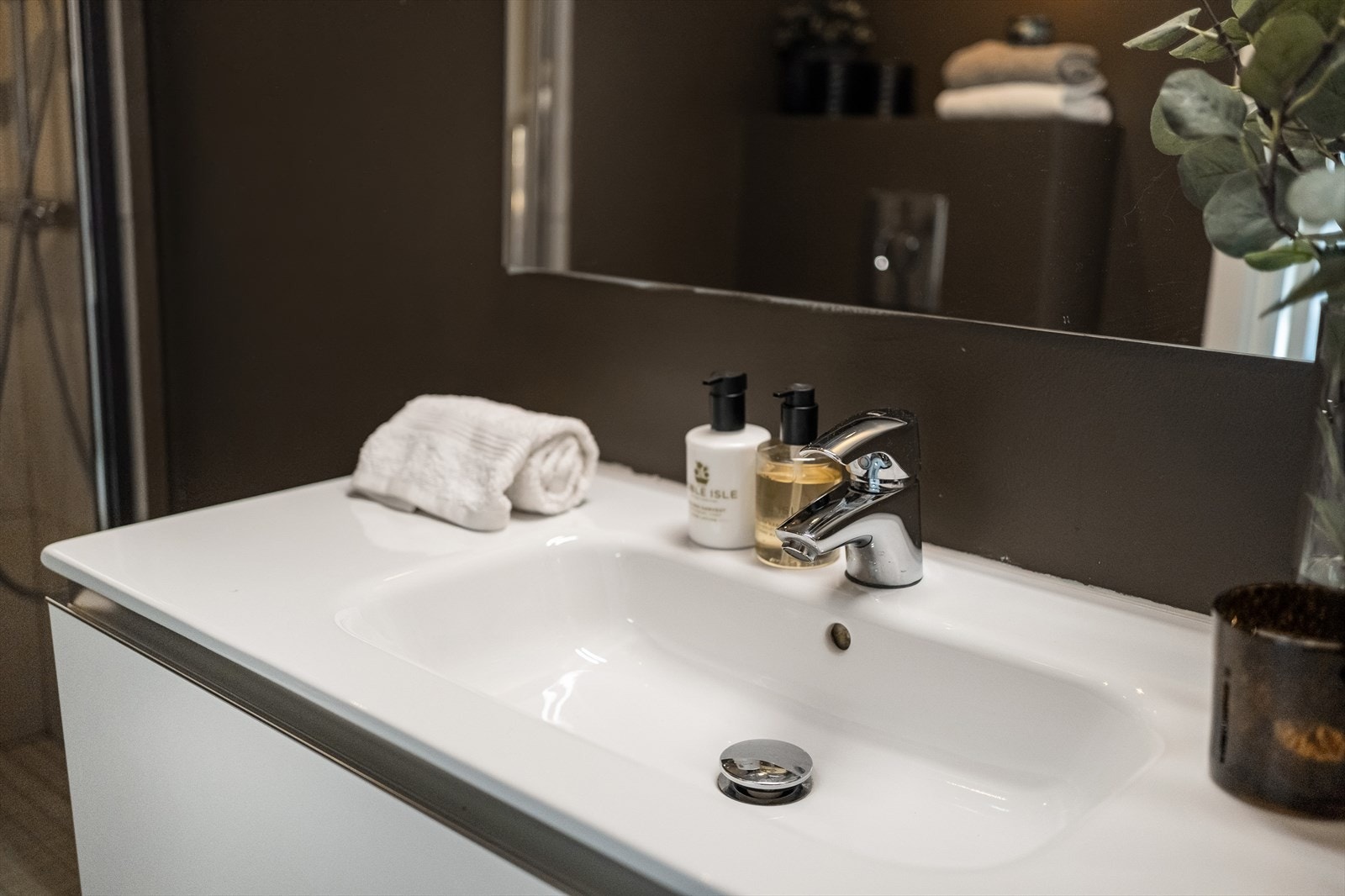 Baderomsinnredning med en nedfelt servant på 100 cm og et ettgreps blandebatteri fra Oras. Over vasken er det speil med belysning. En elektrisk vifte trekker ut luften, og tilluft kommer fra en luftespalte i døren. Galleribilde