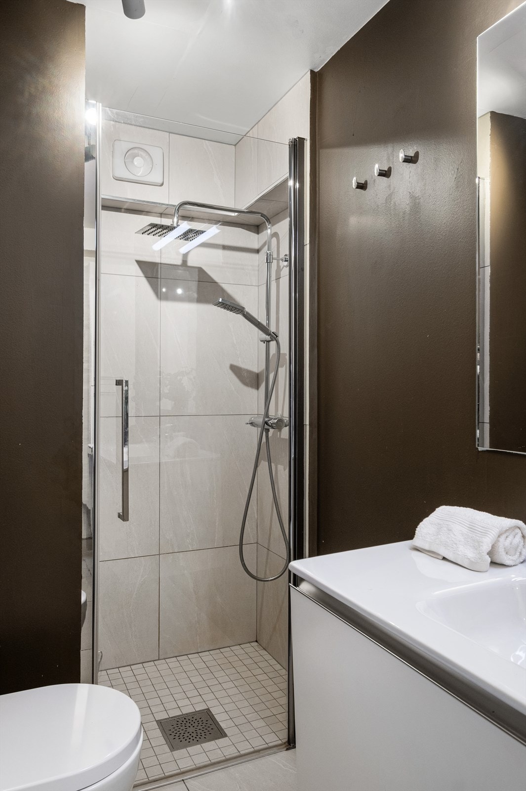 Badet er utstyrt med
veggmontert toalett, dusjvegger/-hjørne og opplegg for vaskemaskin og tørketrommel. Galleribilde