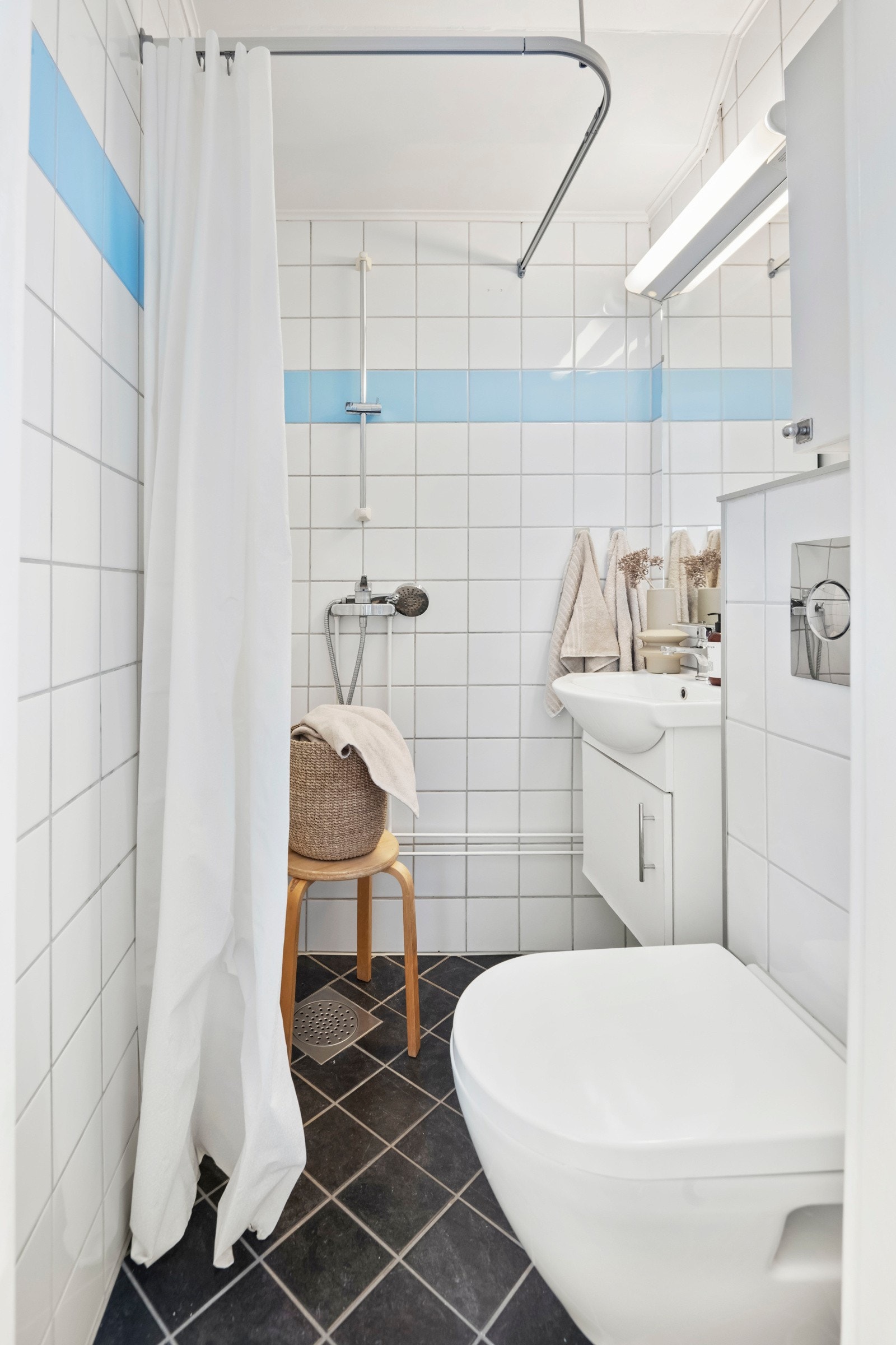 Pent flislagt baderom med lyse og tiltalende flis- og materialvalg. Vegghengt toalett med innebygd cisterne. Galleribilde