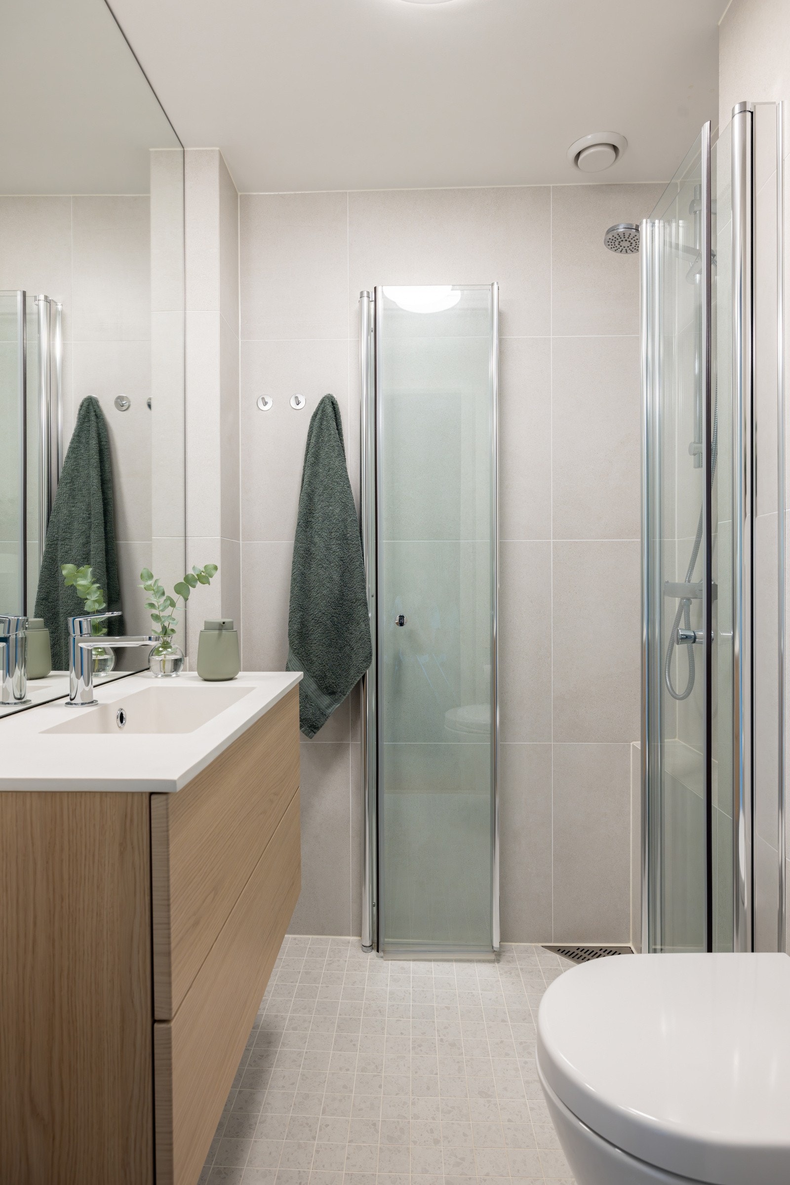 Delikat baderomsinnredning med heldekkende servant og skuffer med slette fronter. Galleribilde