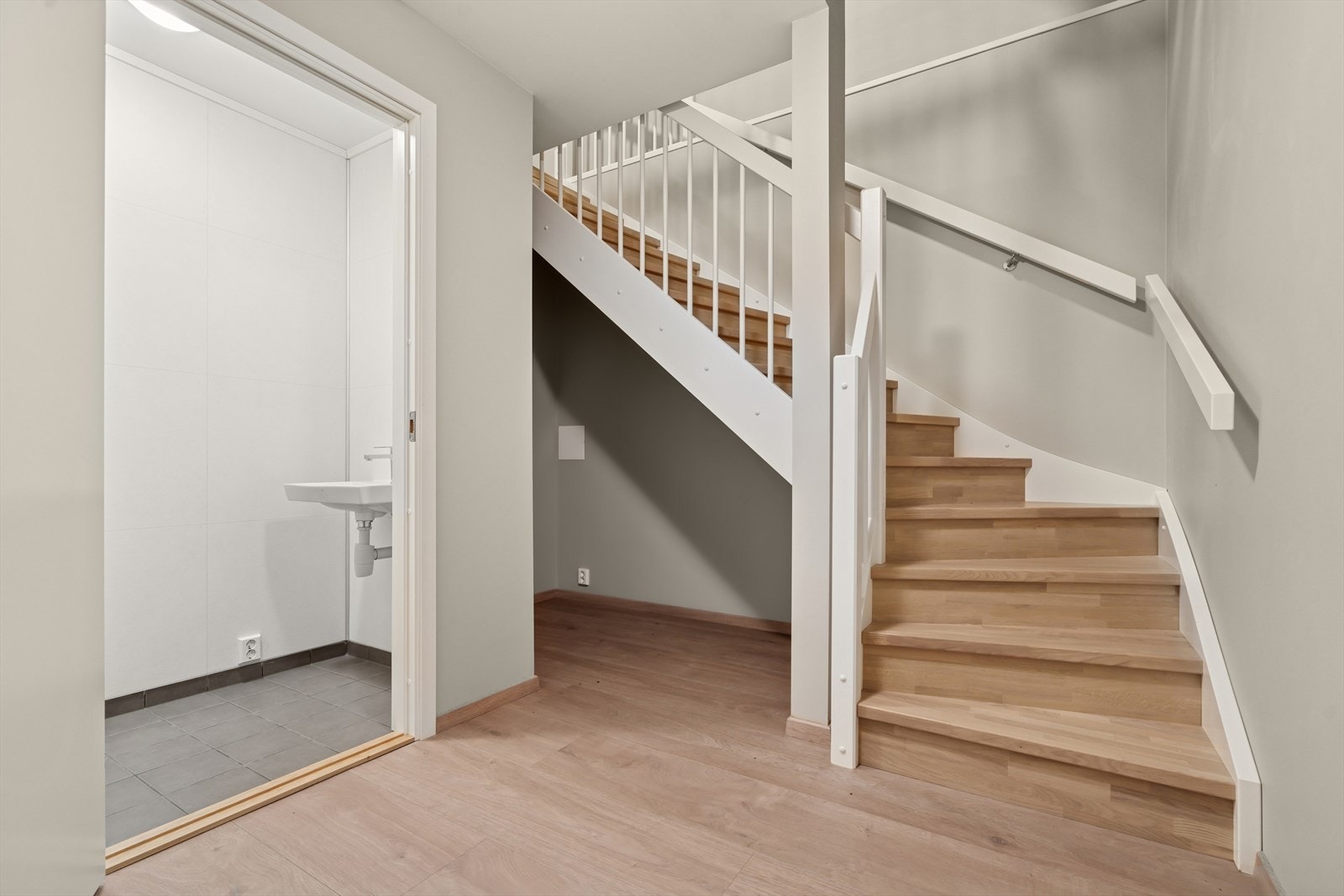 Underetasje hoveddel innredet med toalettrom og vaskerom. Oppbevaringsmuligheter under trapp. Galleribilde