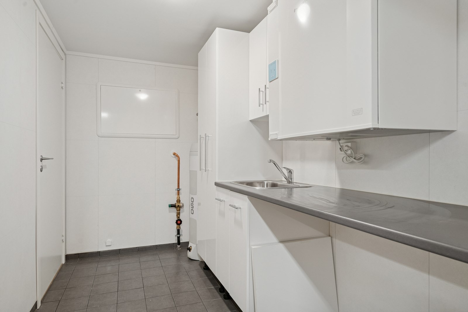 Praktisk og romslig vaskerom med oppbevarings- og arbeidsplass. Galleribilde