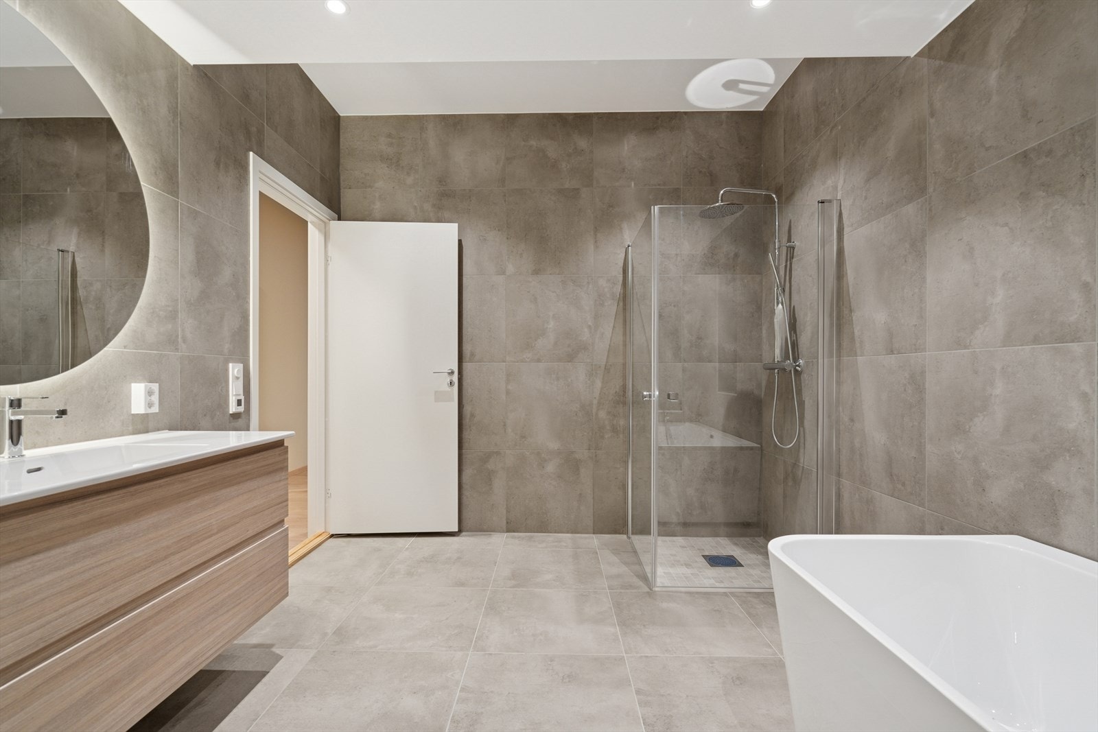 Lekkert velværebad med store 60x60 fliser på vegger og gulv. Perfekt familiebad med både badekar og dusj. Galleribilde