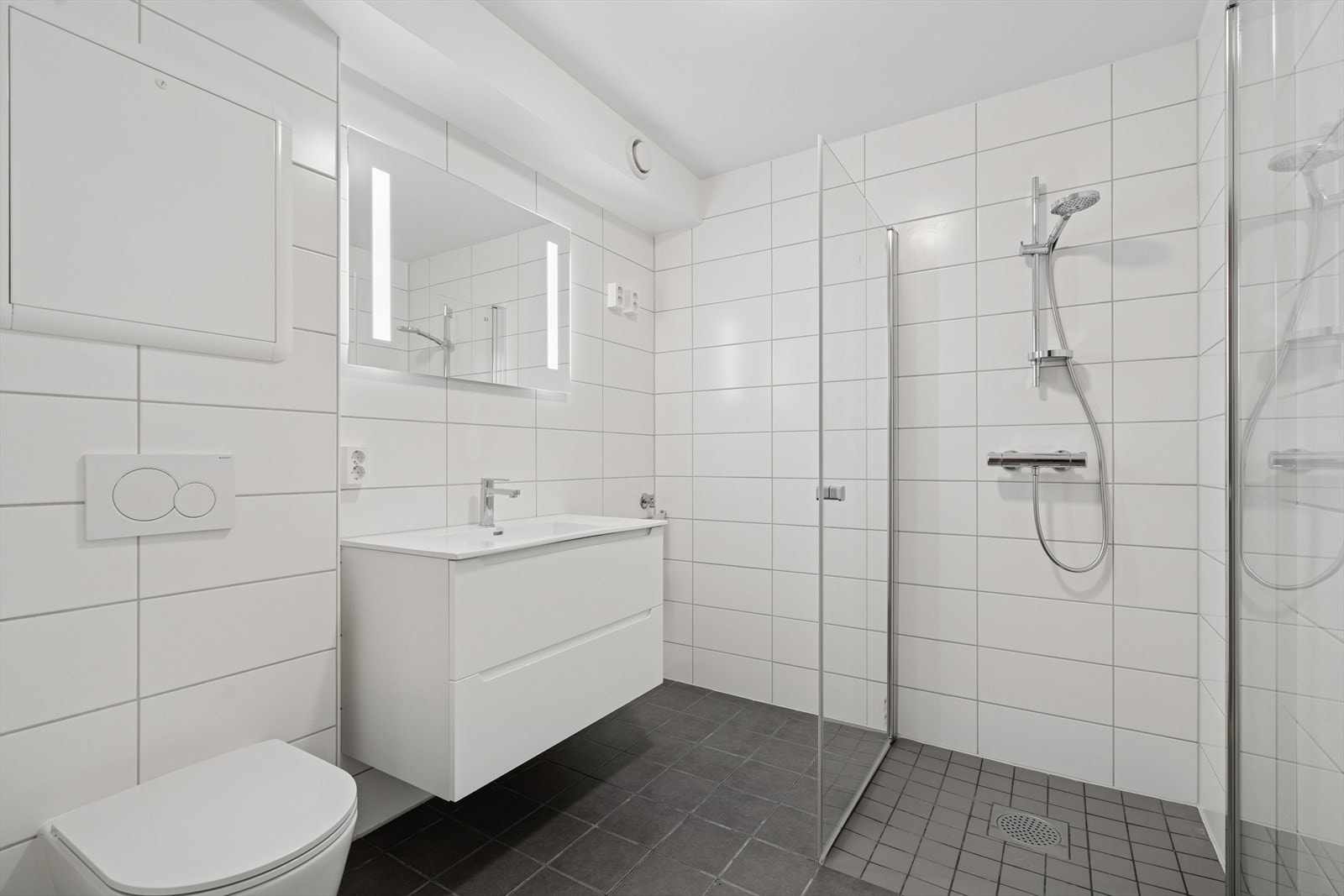 Moderne og innbydende bad med flislagt overflater. Her finnes blant annet opplegg til vaskemaskin. Galleribilde