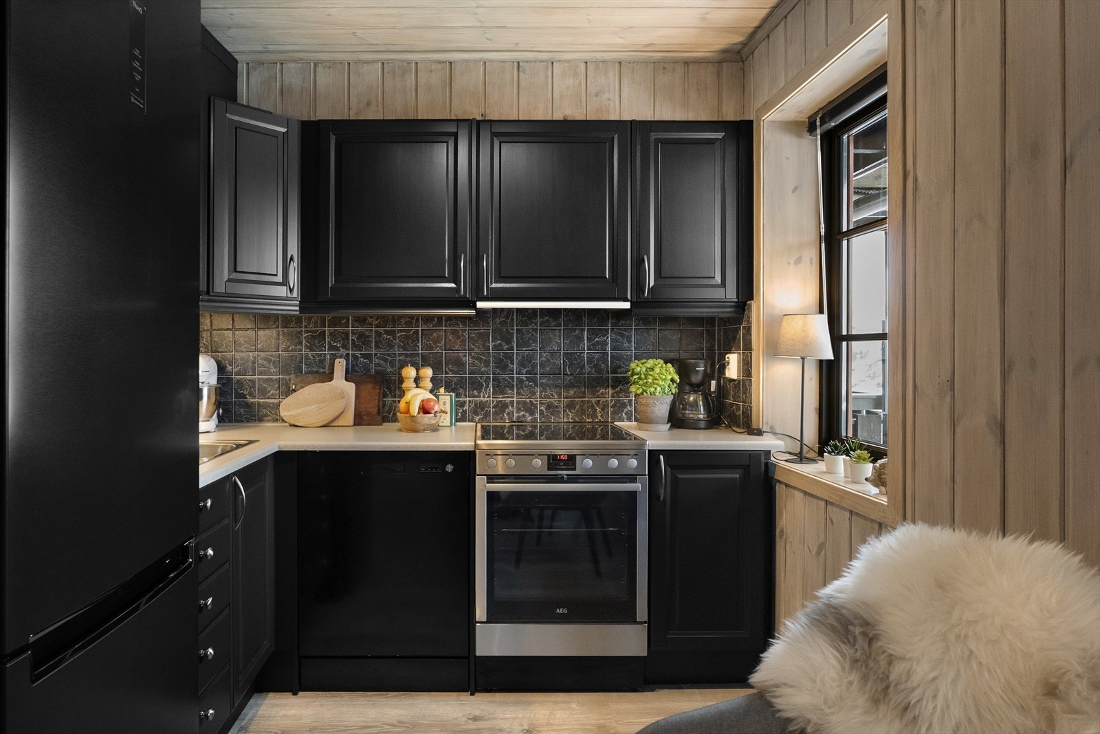 Svart kjøkken med lys benkeplate og god skapplass Galleribilde