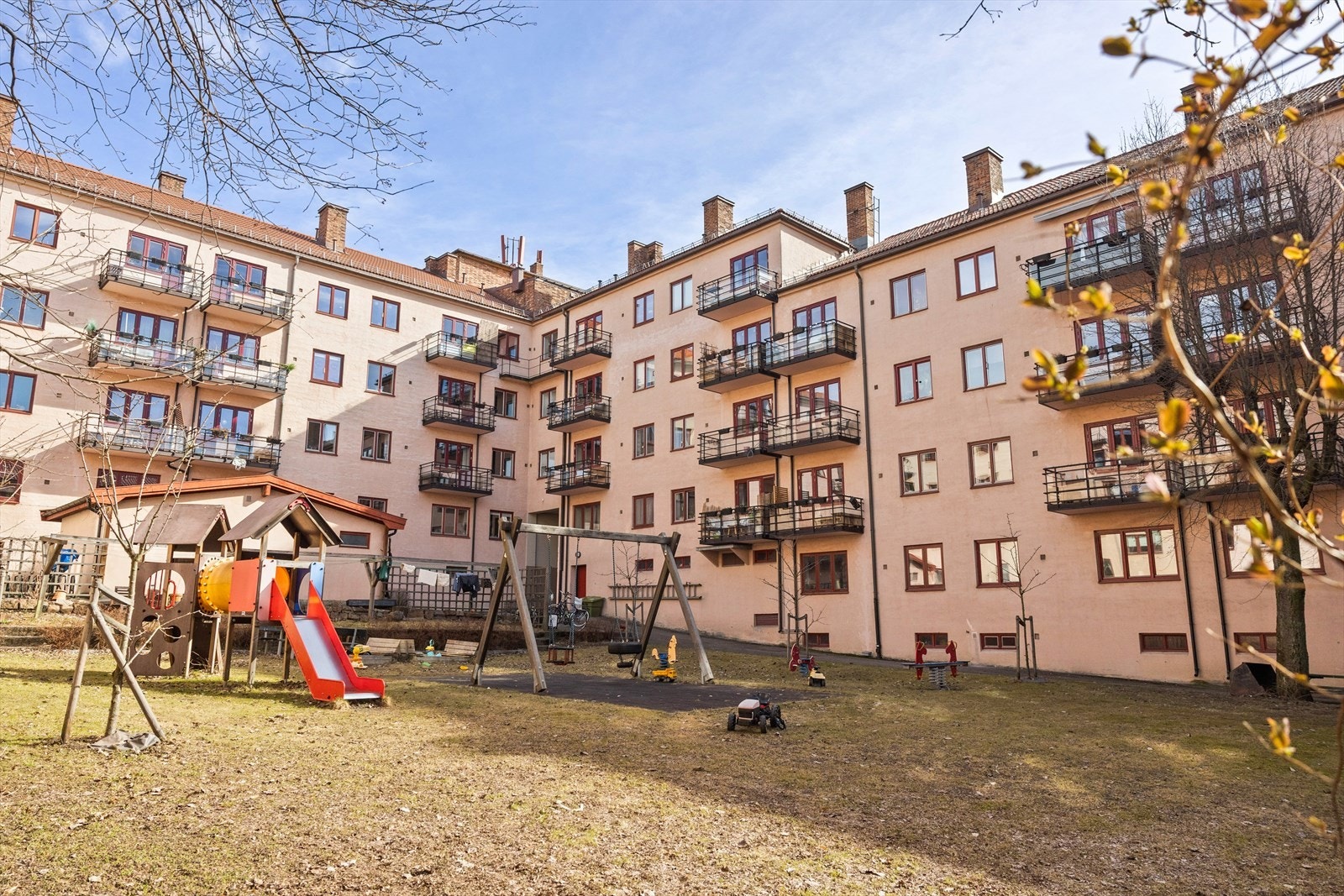 Skjermet felles bakgård, pent opparbeidet med blant annet sittegrupper og lektestativer for de minste. Galleribilde