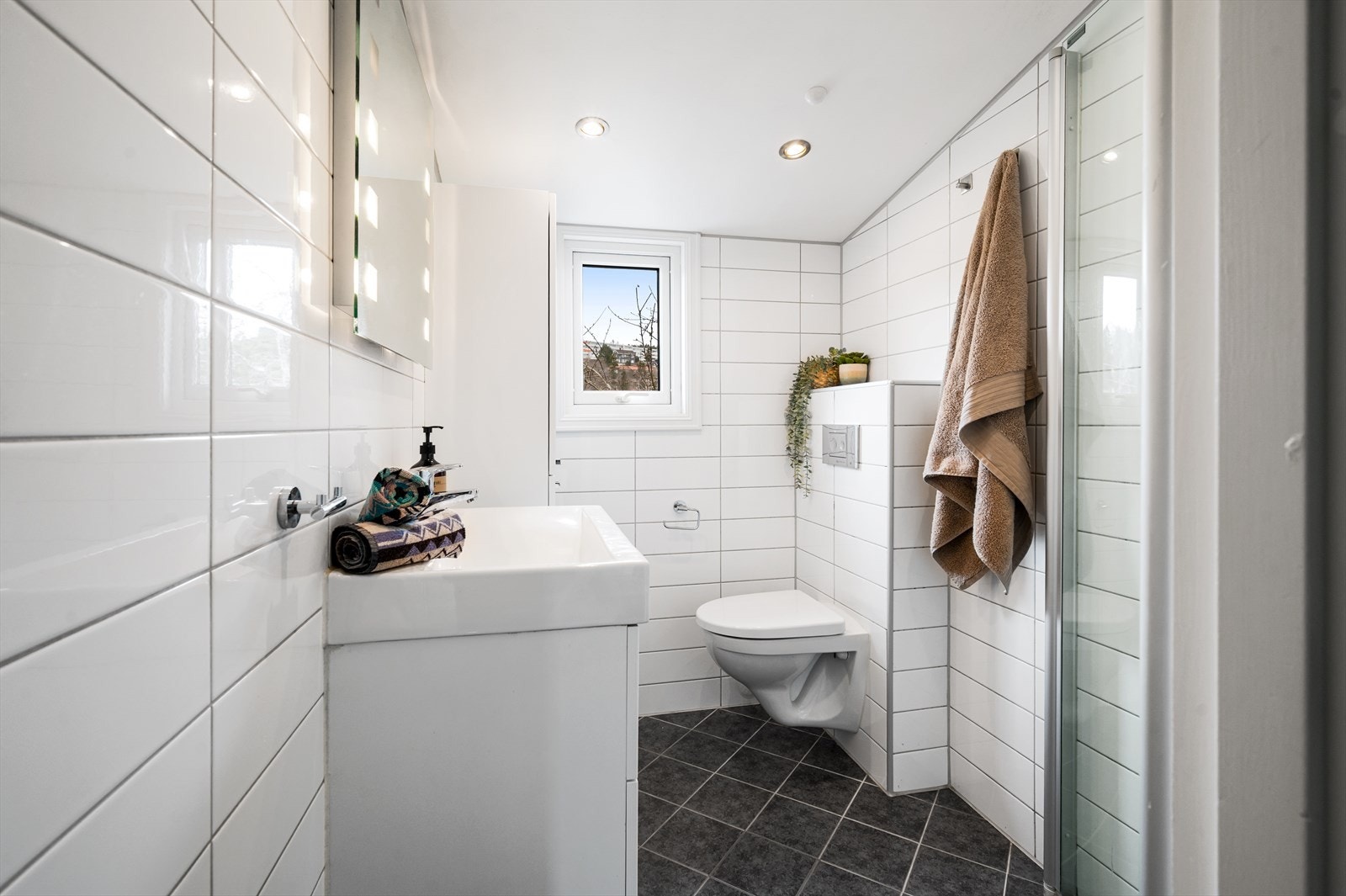 Flott bad fra 2010 med flislagte vegger og gulv med elektrisk gulvvarme, samt innfelte downlights i himlingen. Galleribilde