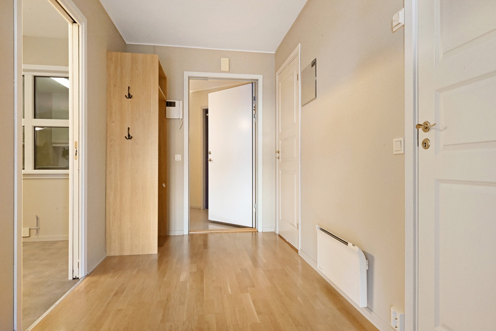 Romslig gang med plass for yttertøy. Her er det også porttelefon og fjernbetjening av ytterdøren i første etasje. Galleribilde