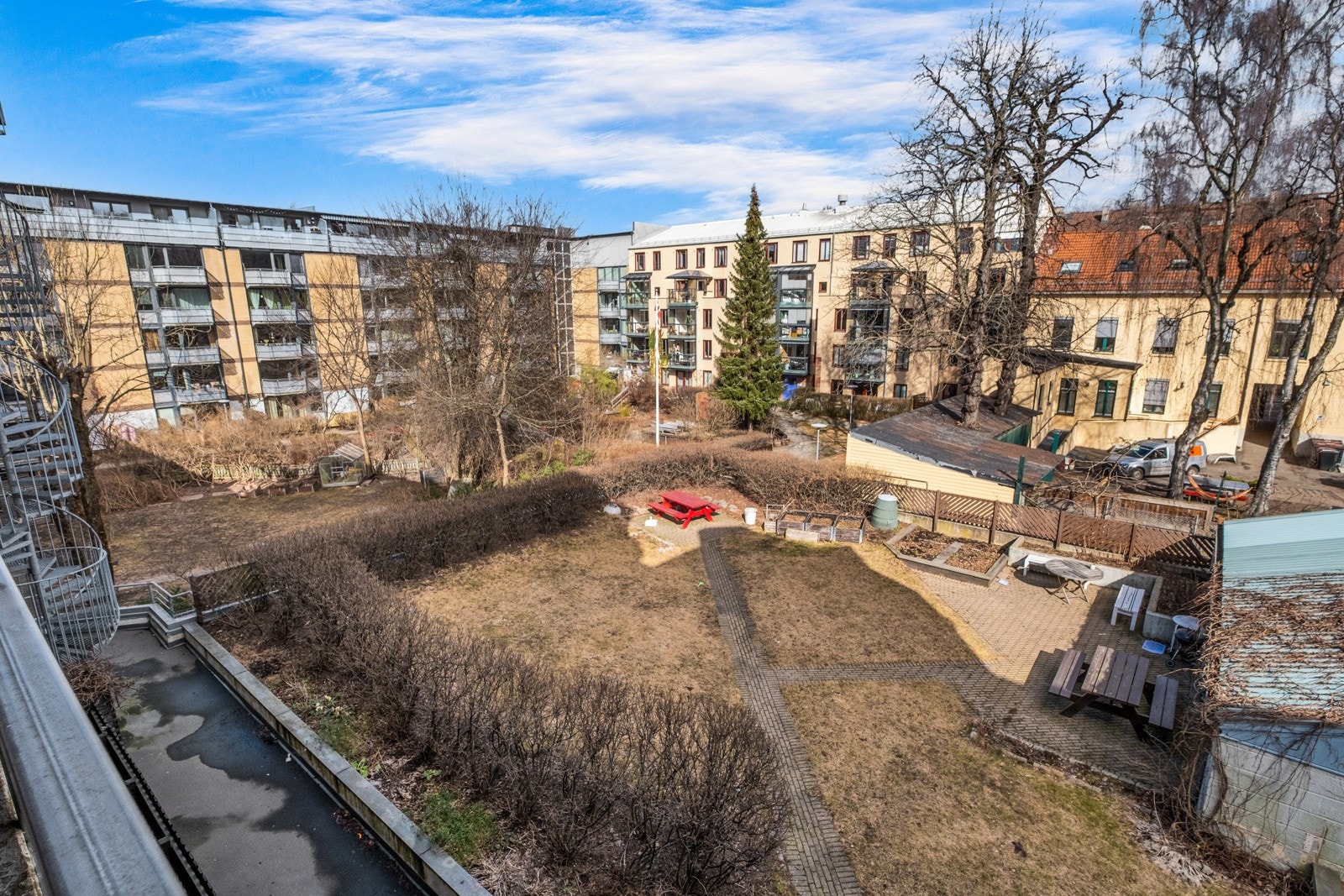 Frodig bakgård med sittegrupper, parsellhage og beplantning Galleribilde