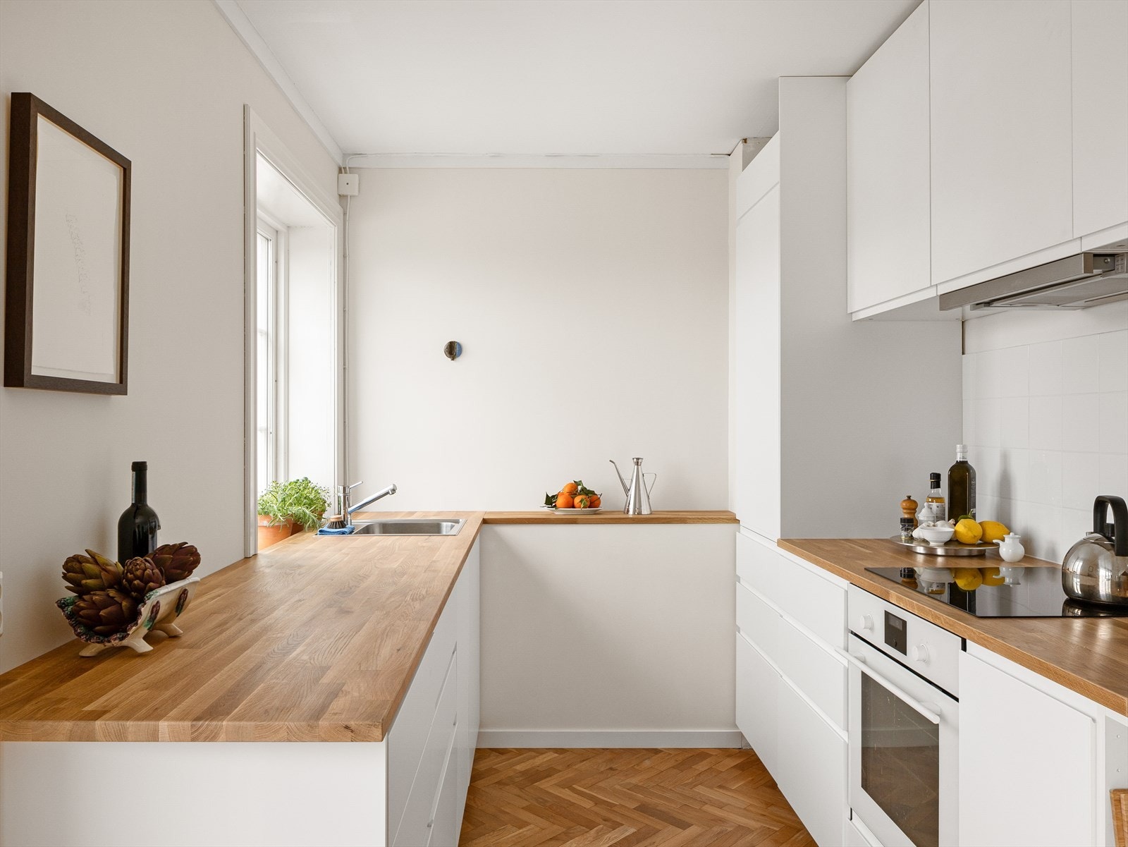 Kjøkkenet er utstyrt med integrert induksjonstopp, ovn og kjøleskap med liten frysedel Galleribilde