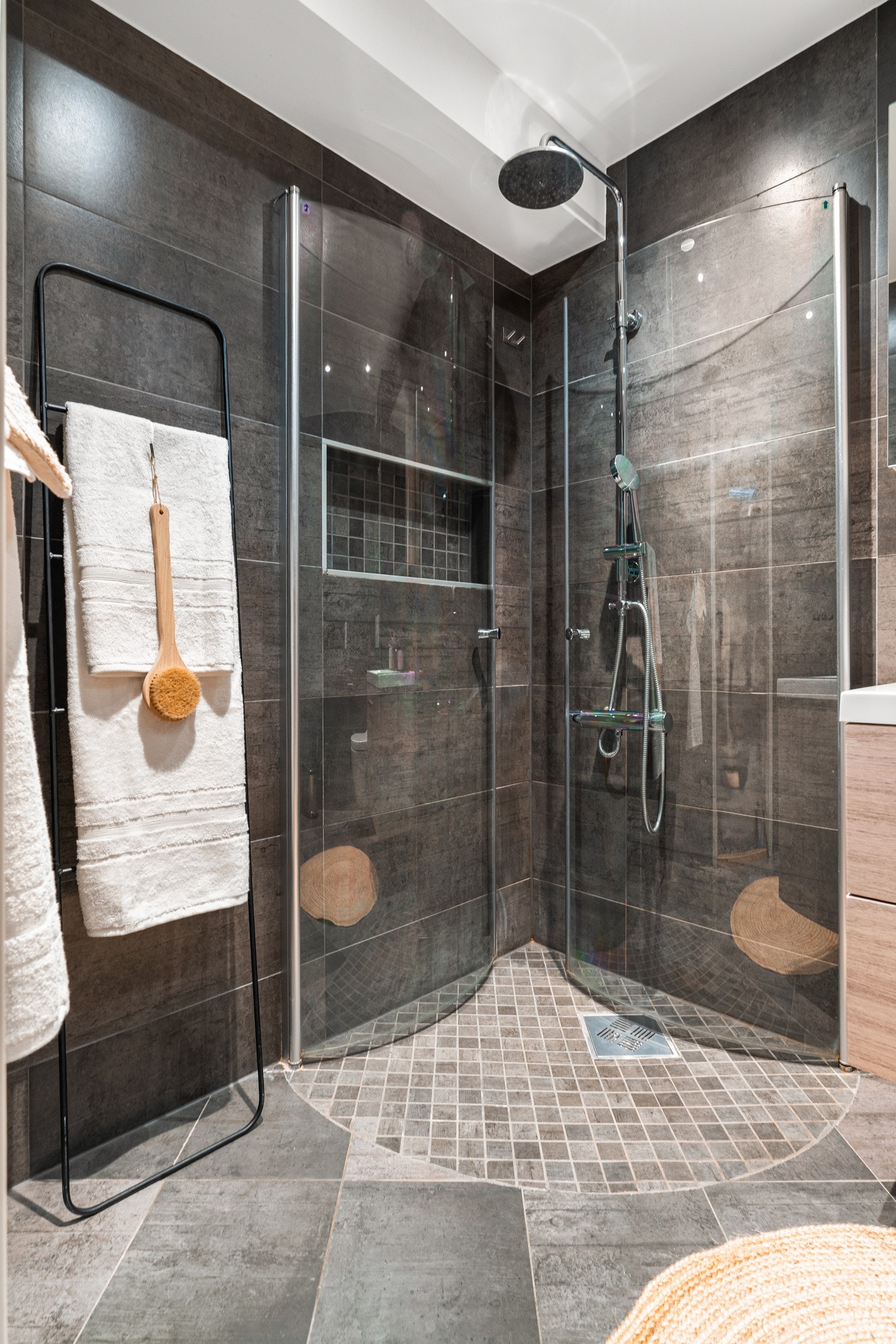 Badet har dusjhjørne med innfellbare glassdører, trope dusj, innfelte spotter og vegghengt toalett med spylefunksjon. Galleribilde