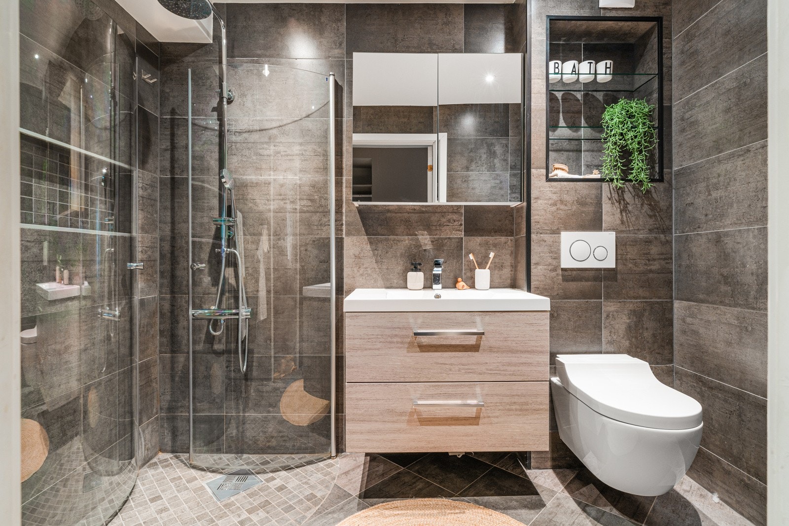 Velholdt baderom fra 2020 på ca. 4 kvm. Baderommet har tidløse fliser på gulv og vegger og innredningen består av speilskap og servant med tilhørende skuffer. Galleribilde