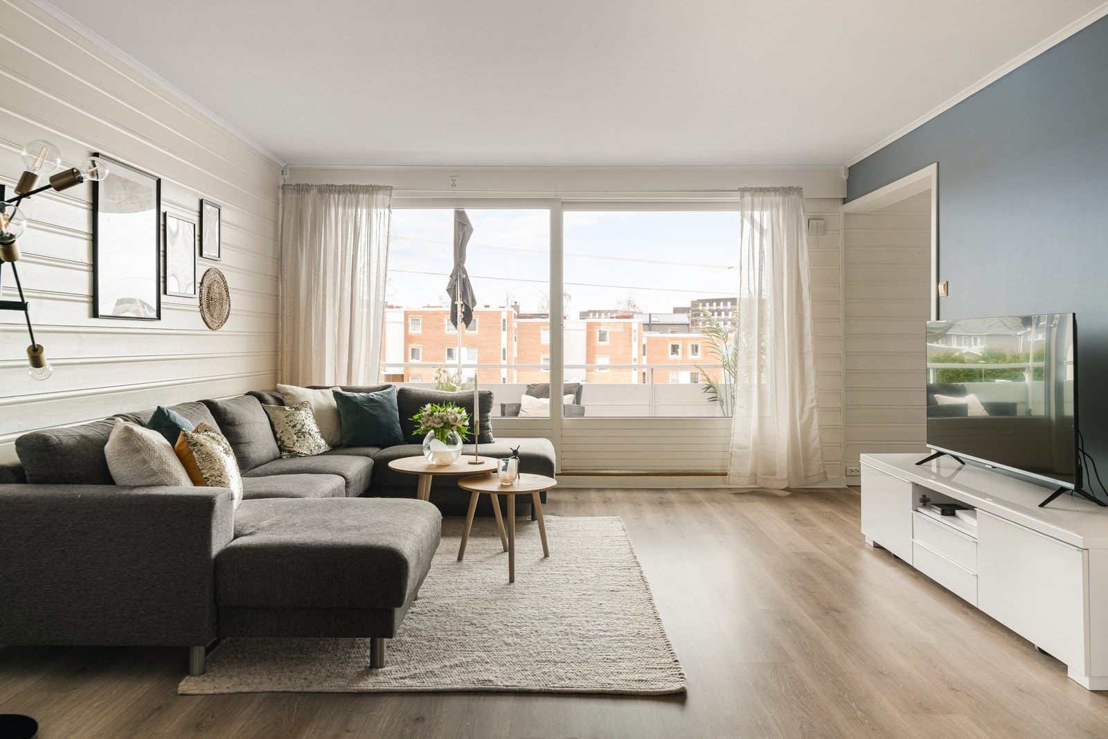 Langveggen er sparklet og malt i en moderne fargetone, teglsteinen på ovnen bidrar til å skape en fin kontrast og det er lagt nytt laminatgulv i 2020. Galleribilde