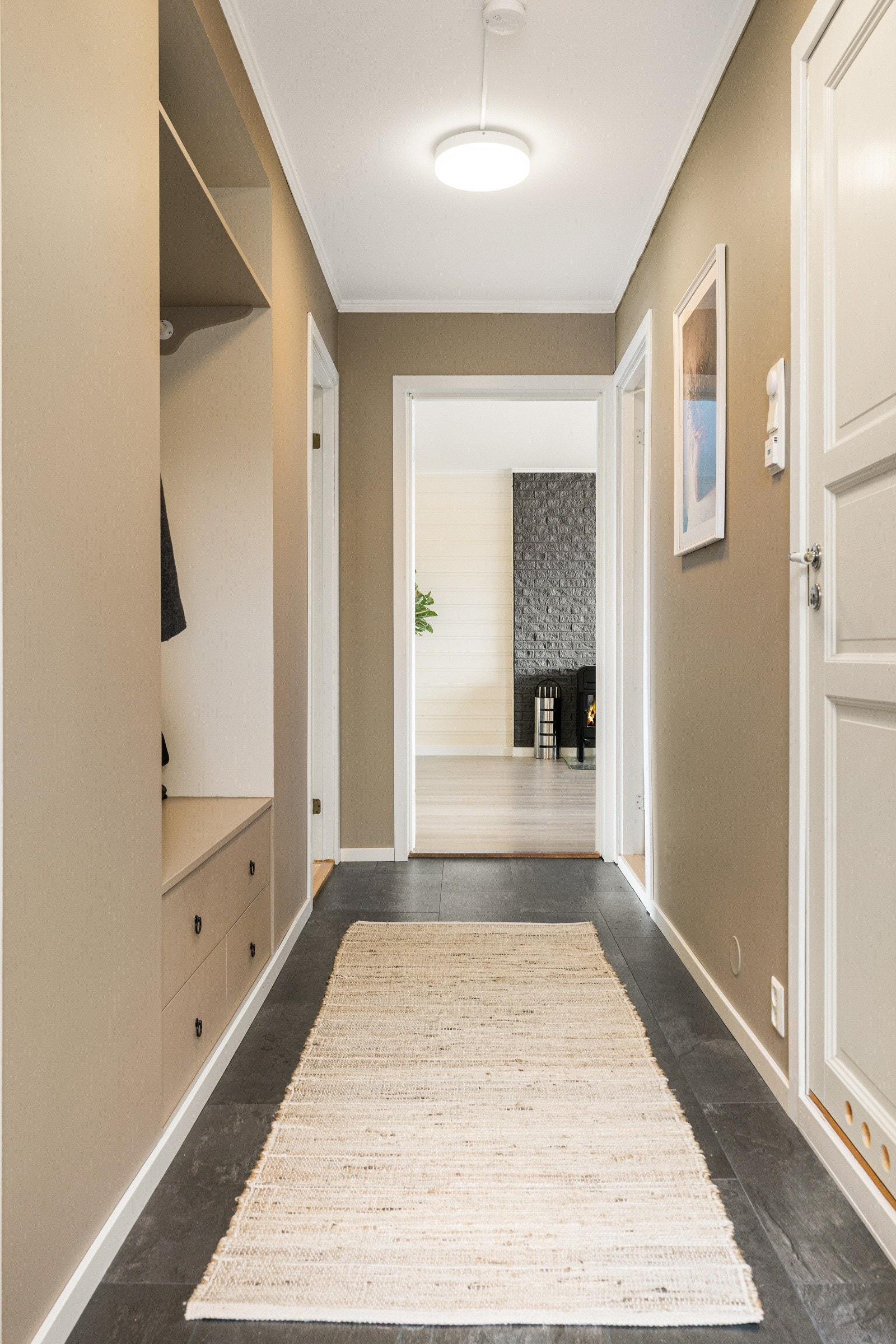 Det er en innbydende entré med god plass for oppbevaring i plassbygd nisje med skuffeløsning. Galleribilde