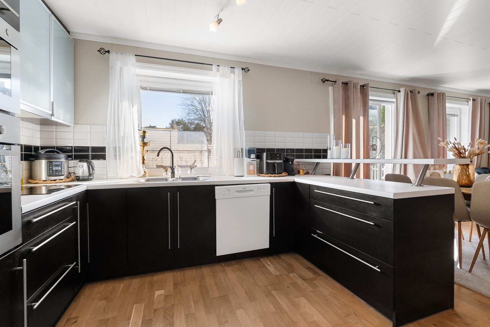 Kjøkken med mørke fronter og imitert trestruktur. Benkeplate i laminat. Galleribilde