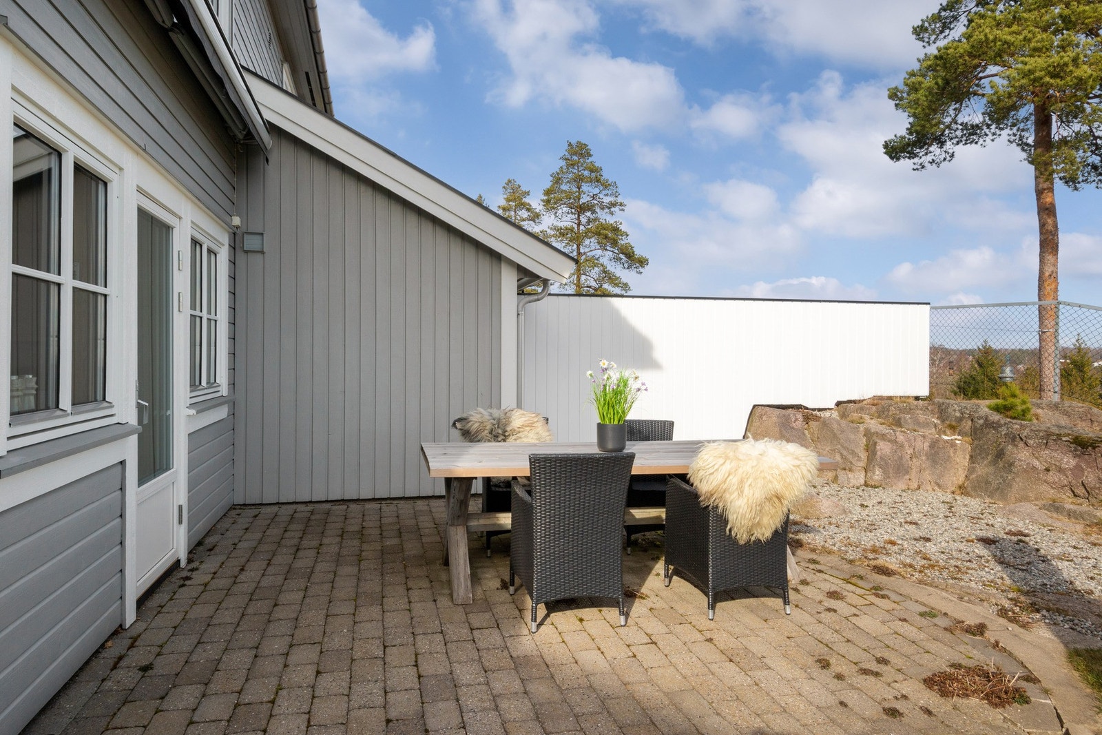 Fra kjøkkenet kommer du ut på en flott, steinbelagt markterrasse. Galleribilde