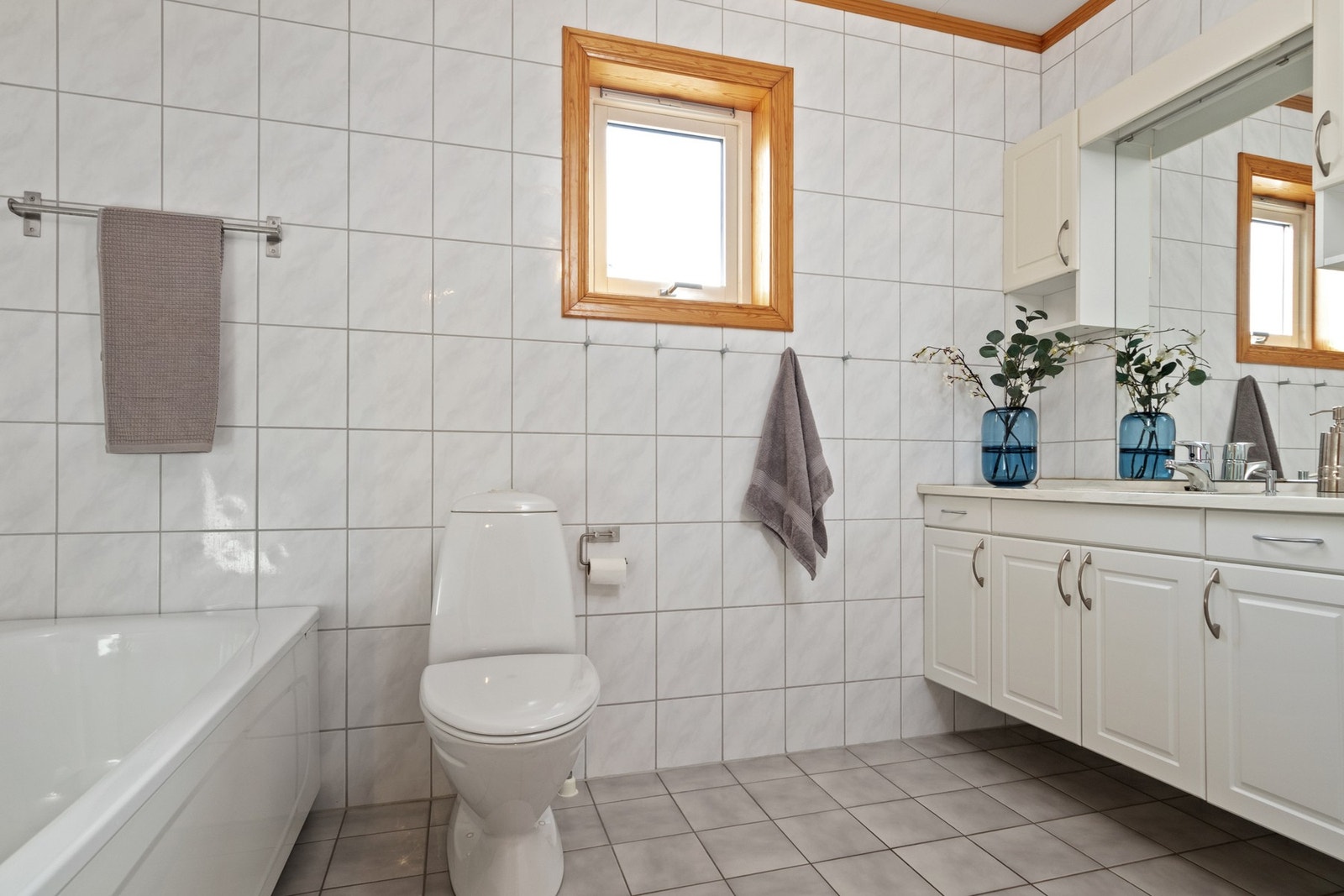 Baderomsinnredningen har hvite, profilerte fronter og består av en heldekkende servant på en skapseksjon, to veggskap og et speil med belysning. Galleribilde