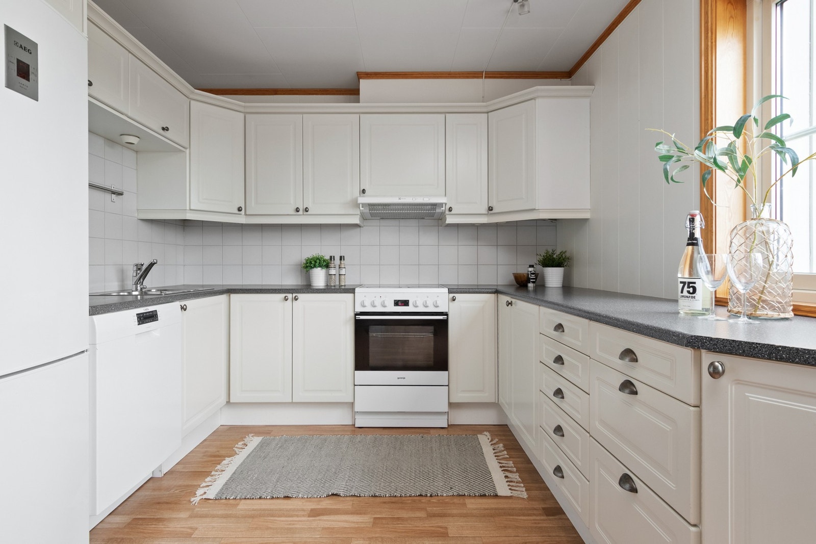 Veggene over benken er kledd med hvite fliser som står godt til resten av interiøret. Videre er kjøkkenet utstyrt med ventilator, benkestikk, benkebelysning og opplegg for oppvaskmaskin. Galleribilde