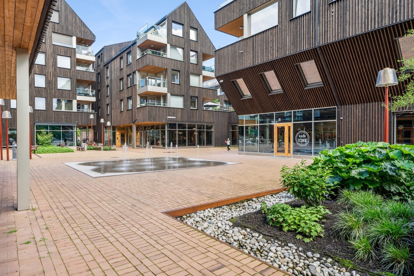 Nærområde med kafeer, butikker og fontene Galleribilde