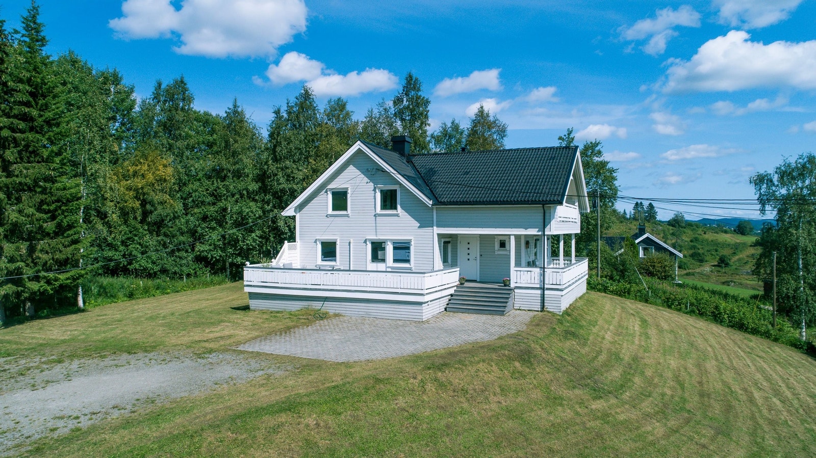 Huset har romslig gårdsplass med grus og brolegningsstein. Ligger på en høyde med sol hele dagen. Galleribilde