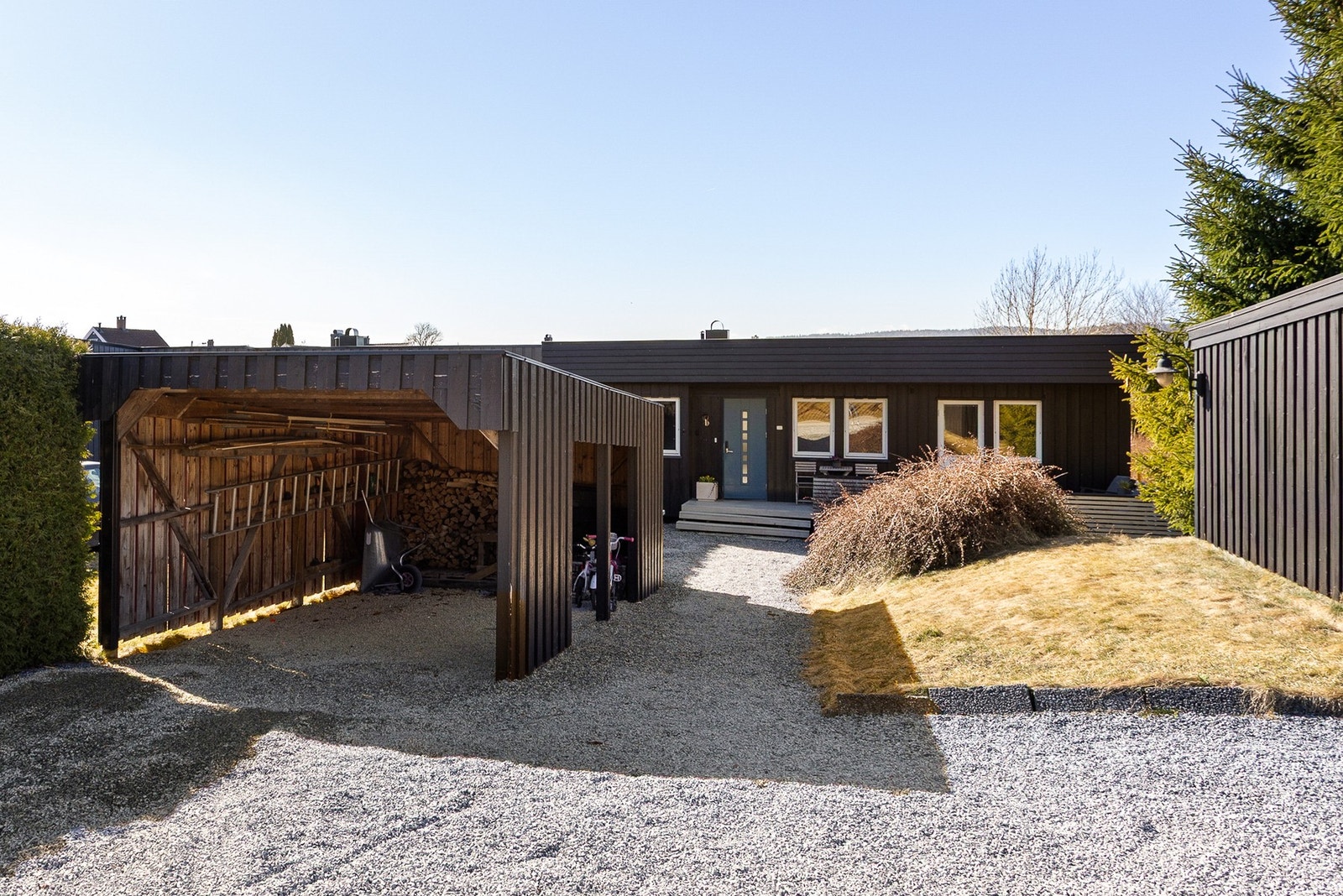 Eiendommen har en gruset innkjørsel med flere biloppstillingsplasser rett ved inngangsdøren, samt parkering i egen garasje og carport. Galleribilde