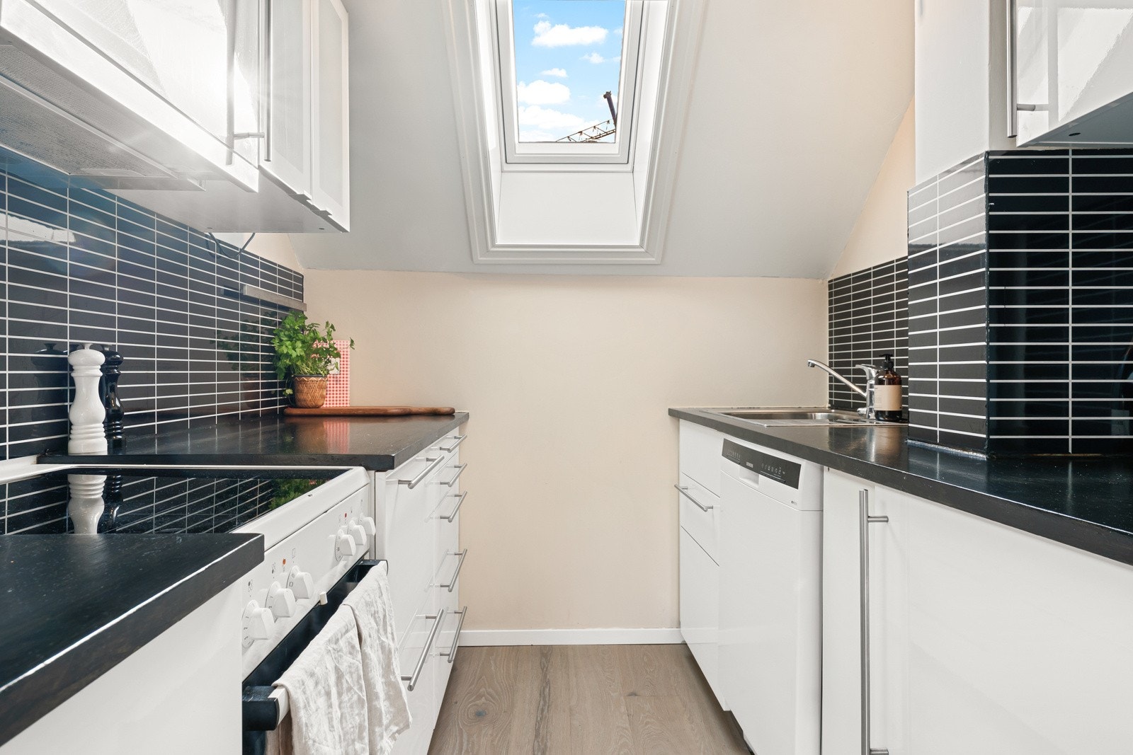 - Kjøkkeninnredningen har slette fronter og en heltre benkeplate - Galleribilde