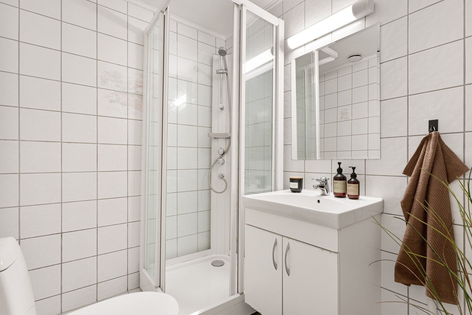 Badet har noen sprekker i flis på vegg og gulv. Galleribilde